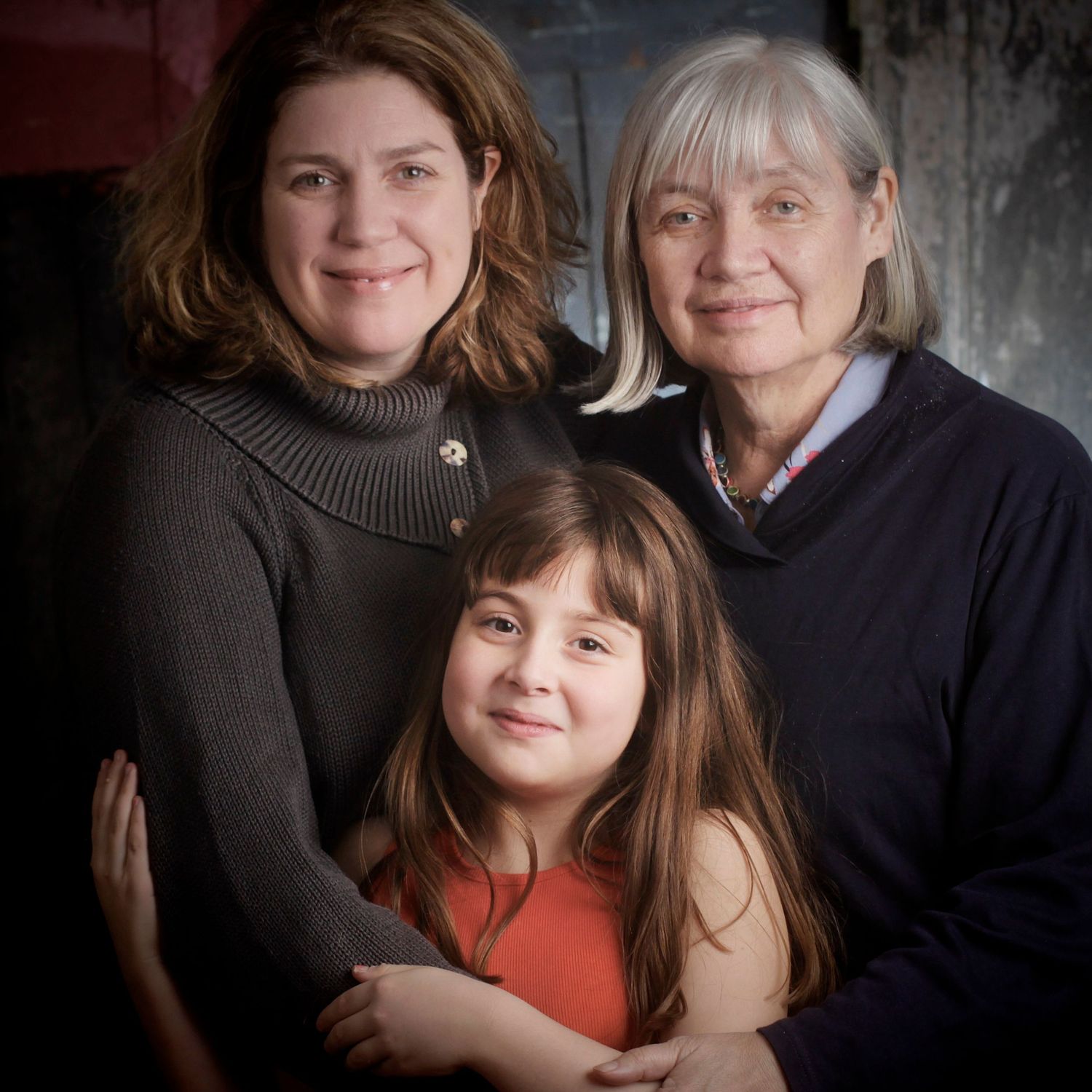 Family portrait series with warm expressions against dark textured backdrop showing close bonds and affection.
