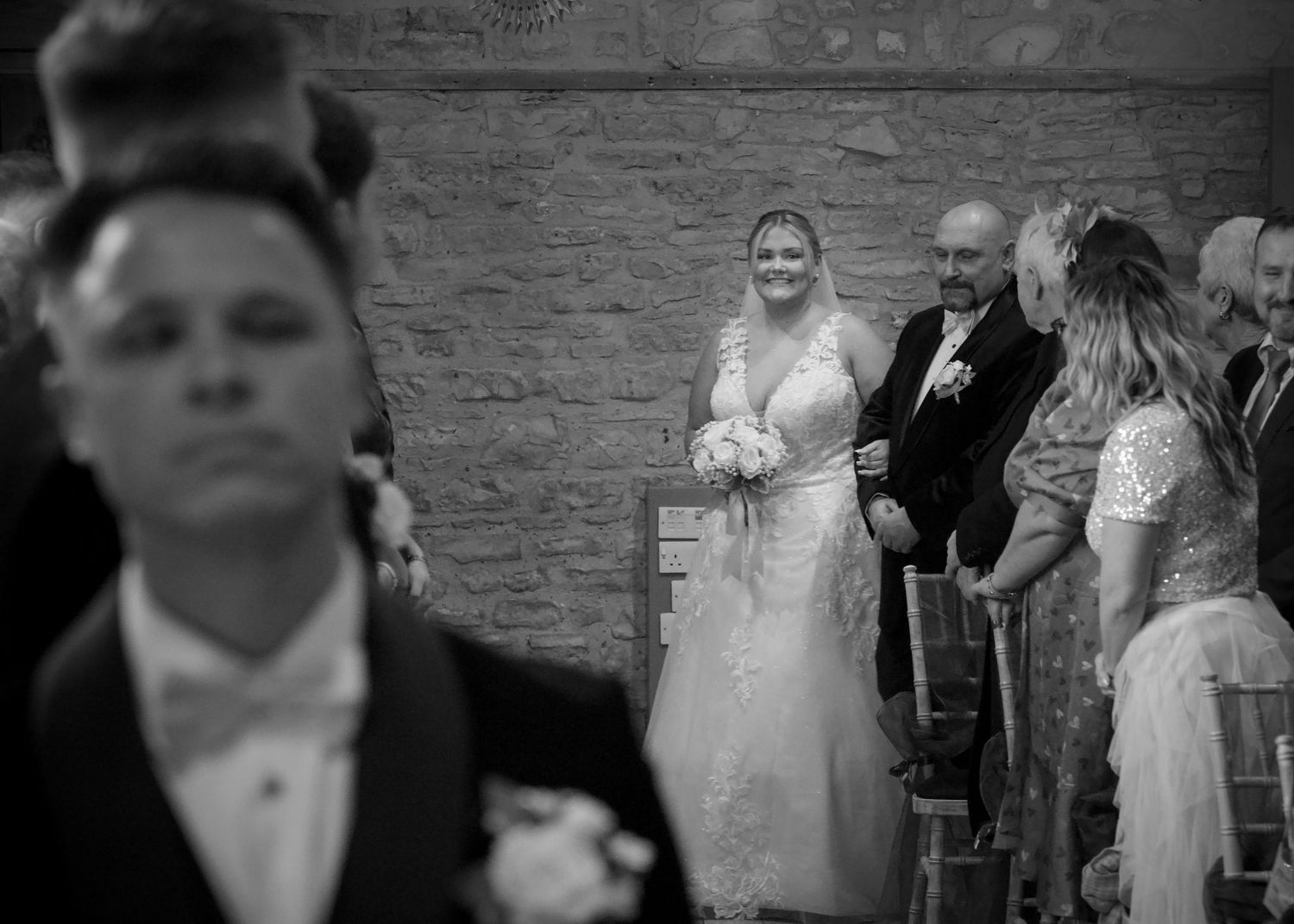 Black and white wedding ceremony photos showing intimate moments in a rustic venue.