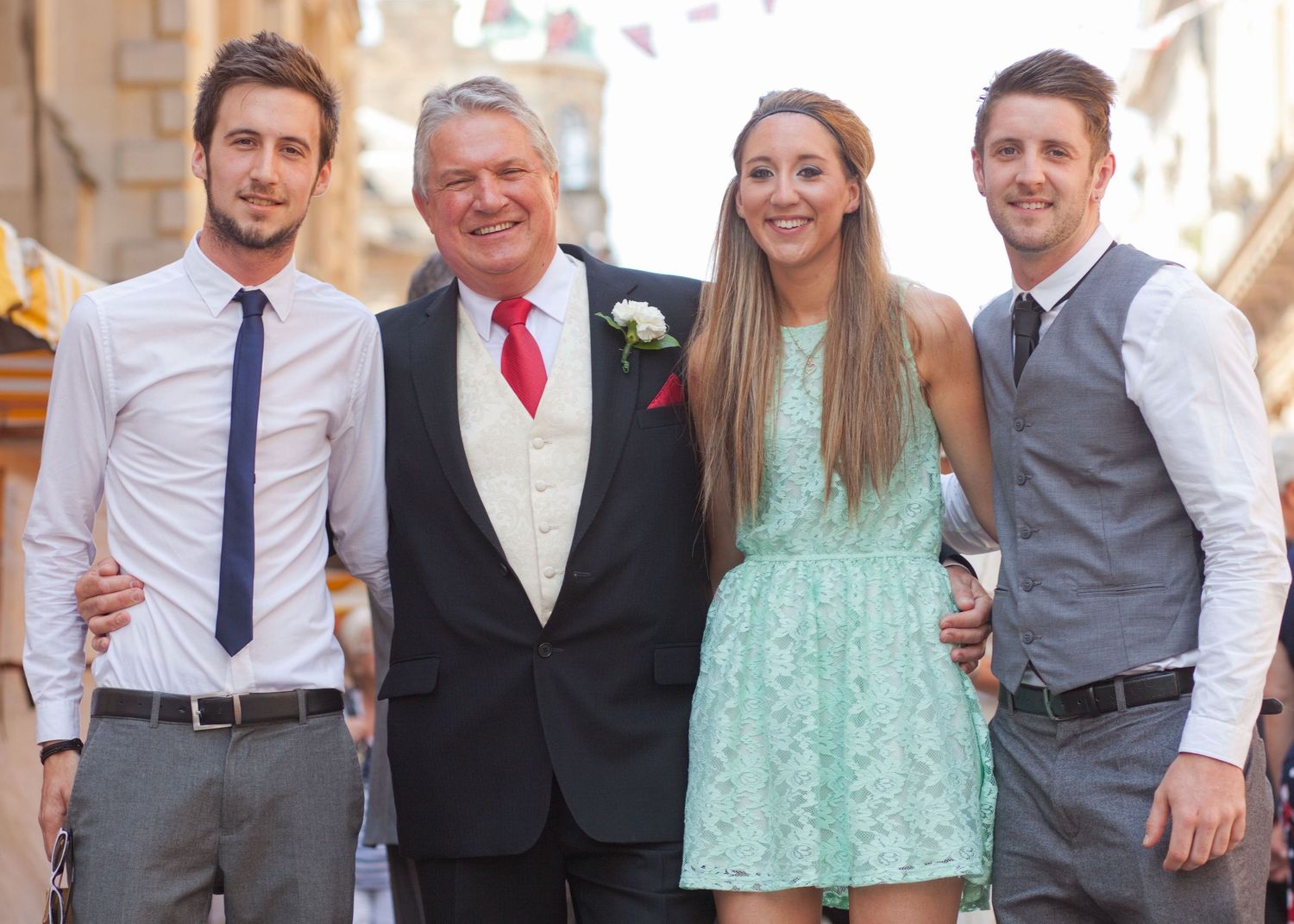 Wedding party members in suits and dresses pose together for group photos.