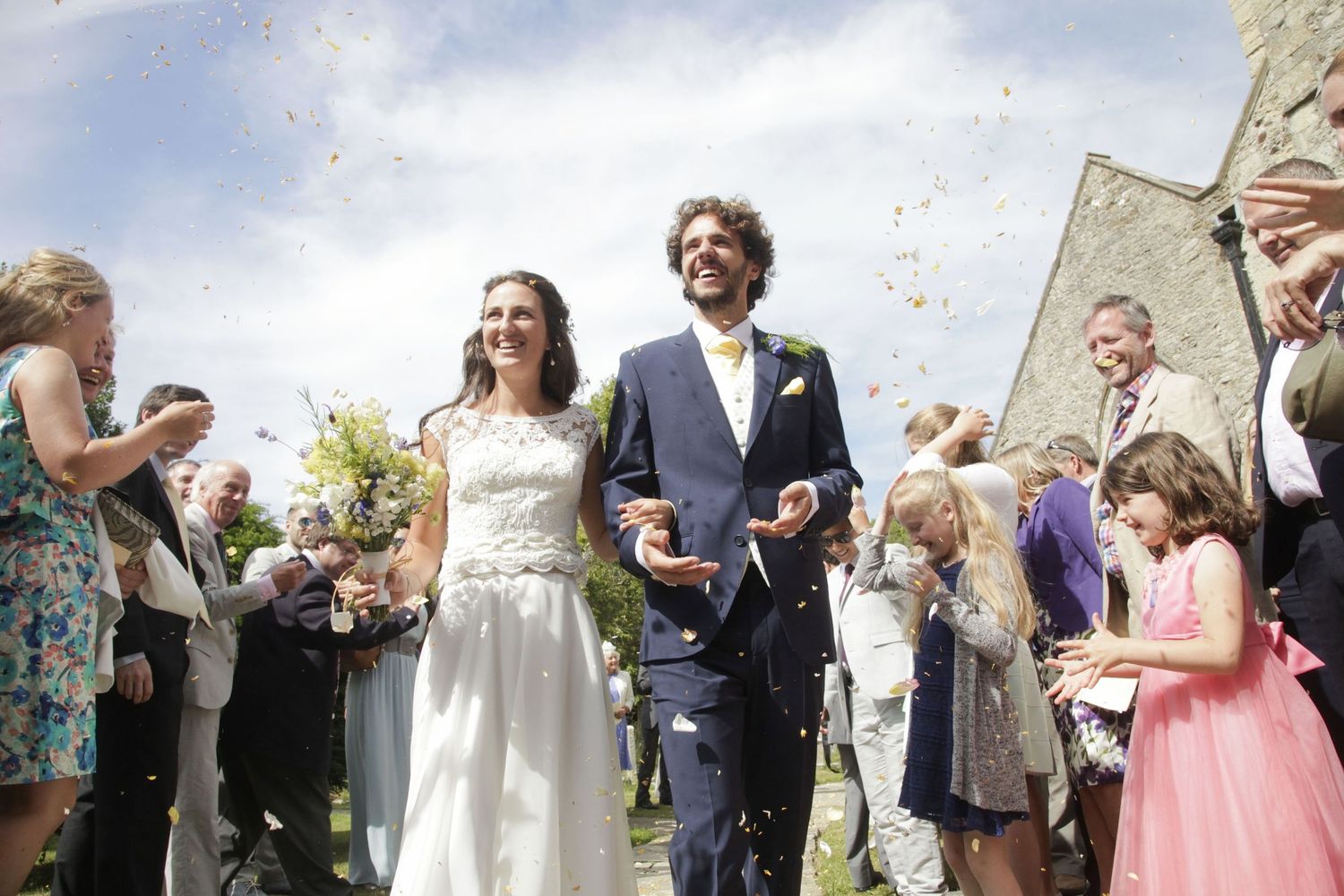 Guests shower newlyweds with confetti during outdoor wedding festivities.