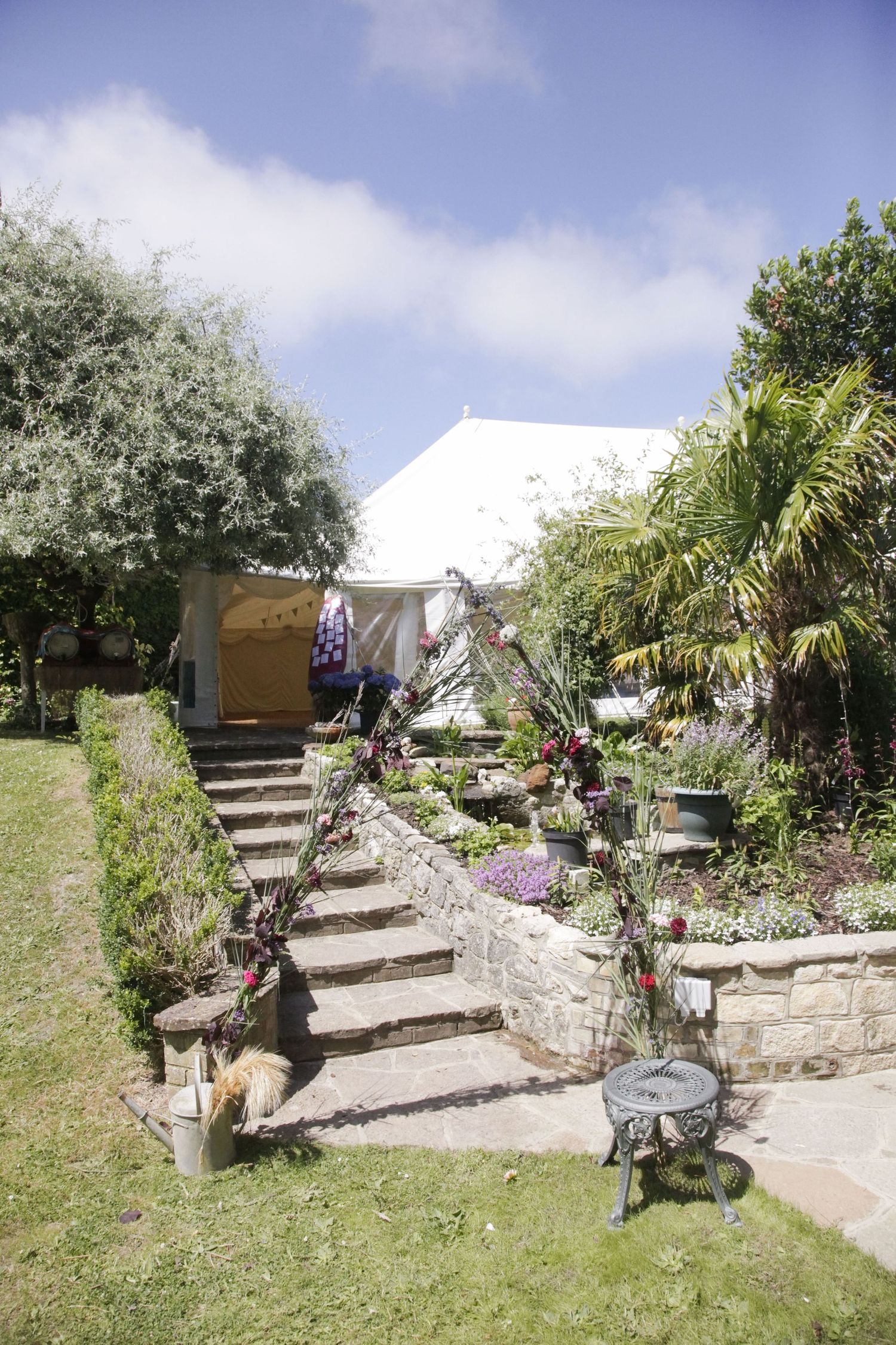 Stone garden steps leading up a grassy hill with decorative planters.