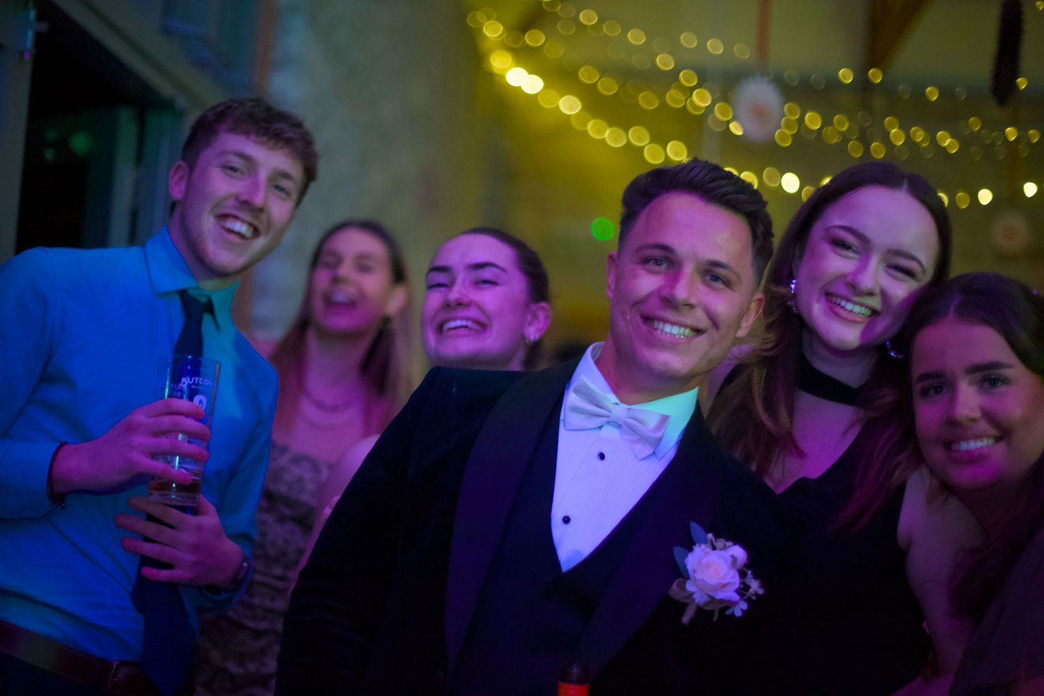 Party scene with string lights and colorful ambient lighting creating festive atmosphere.