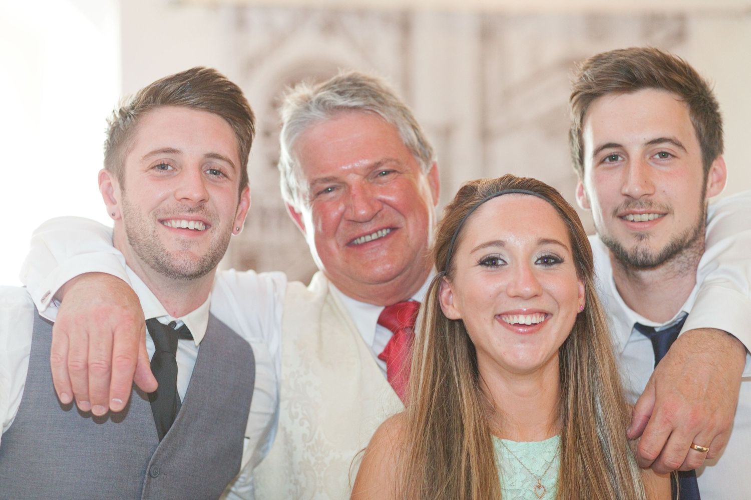 Group portrait showing multiple people smiling together in formal wear.