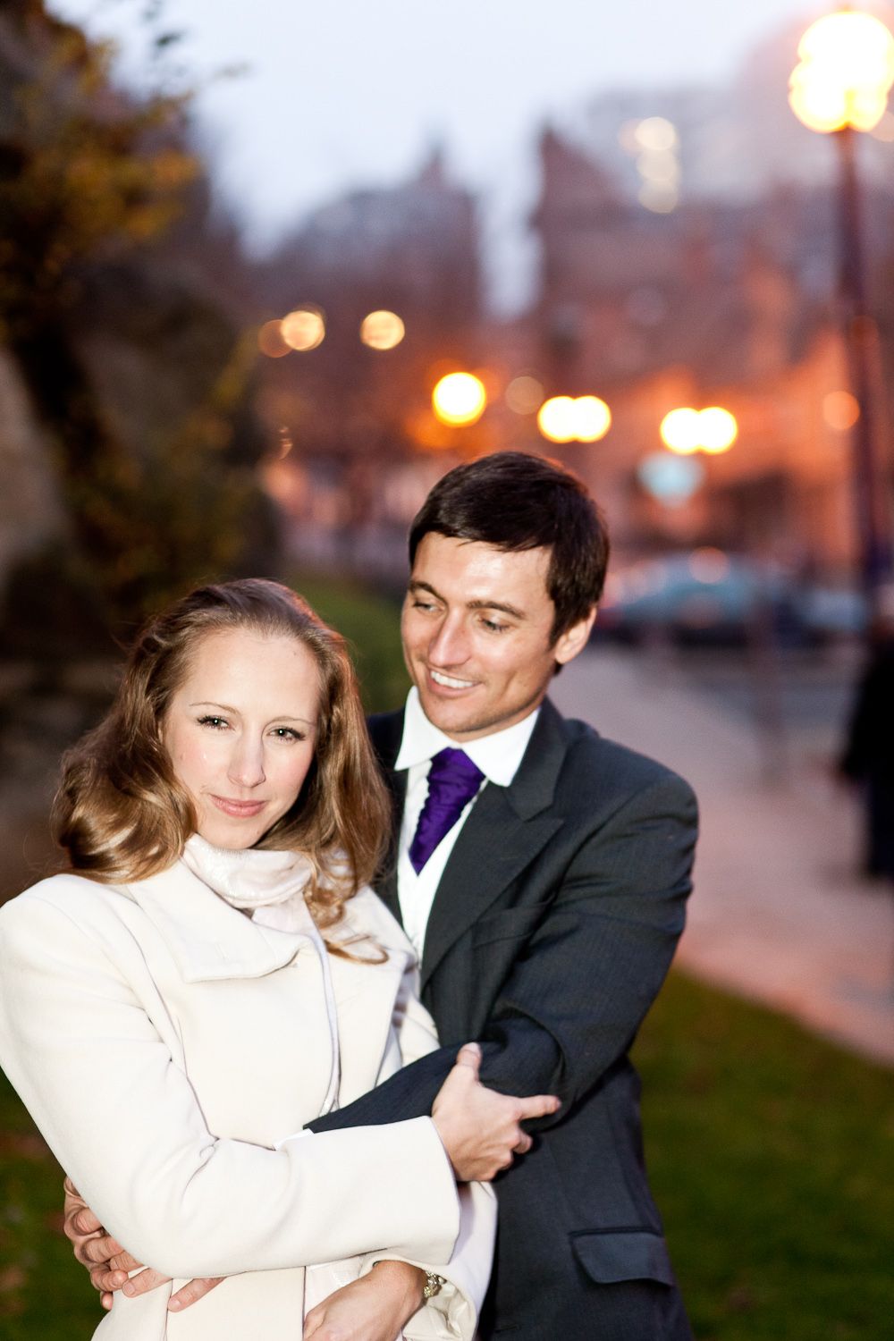 Romantic evening engagement photos with couple in white coat and dark suit.