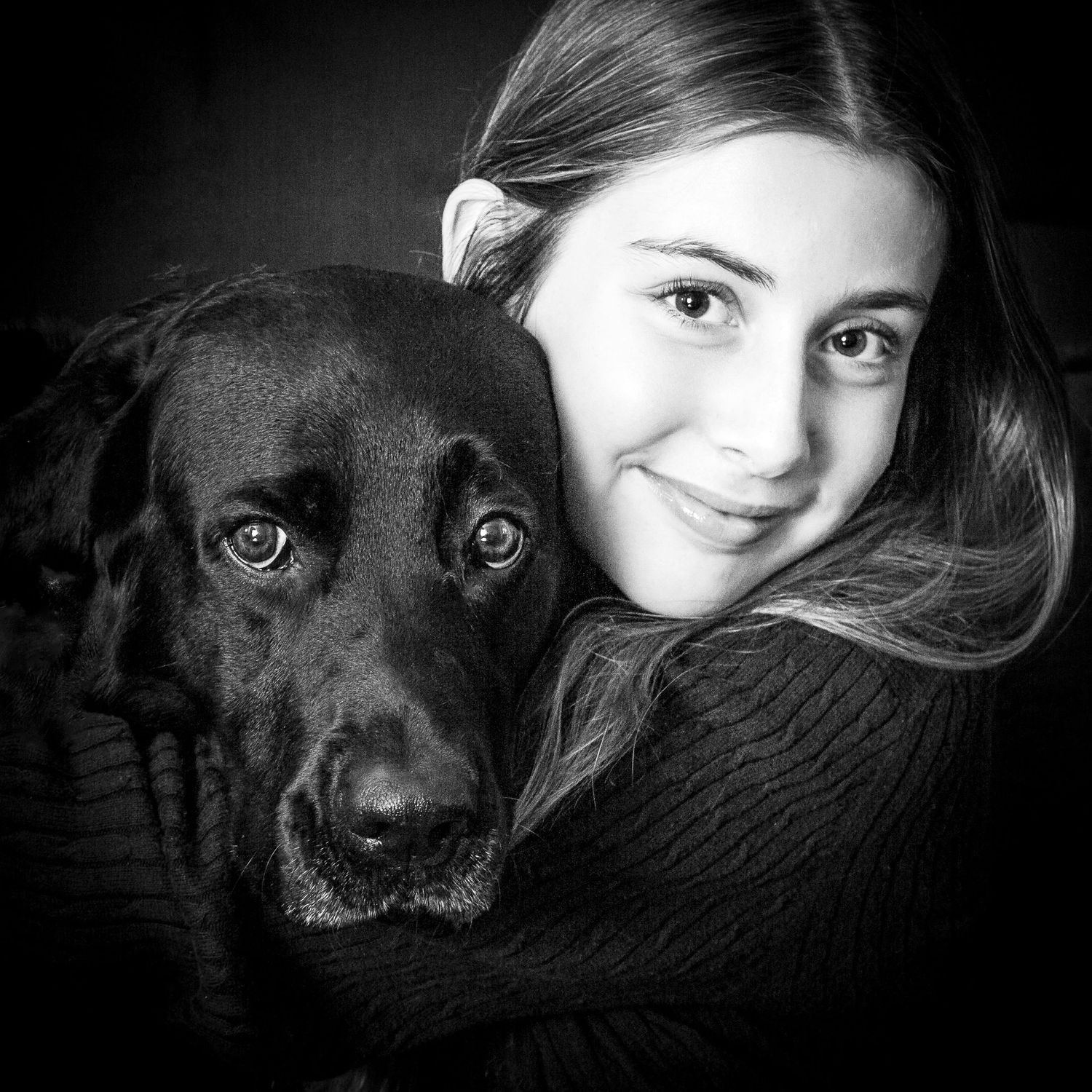 Black and white portraits of a person and their black dog showing their close emotional bond and companionship.