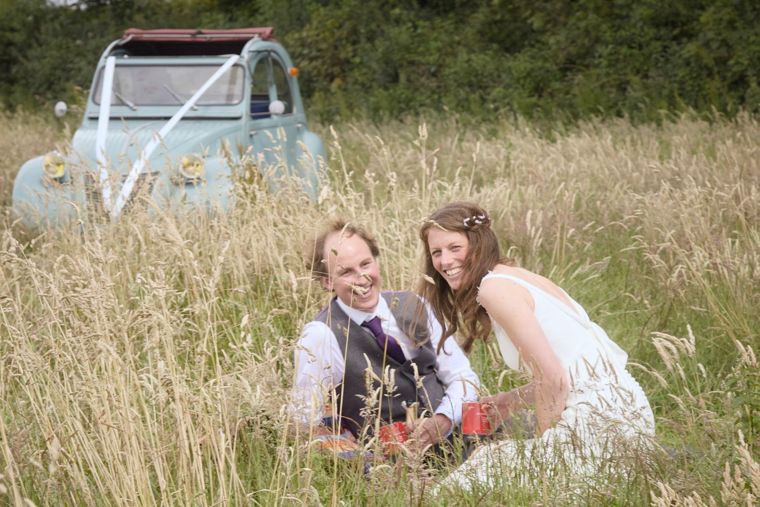 People relaxing in a sunny meadow with tall grass and natural lighting.