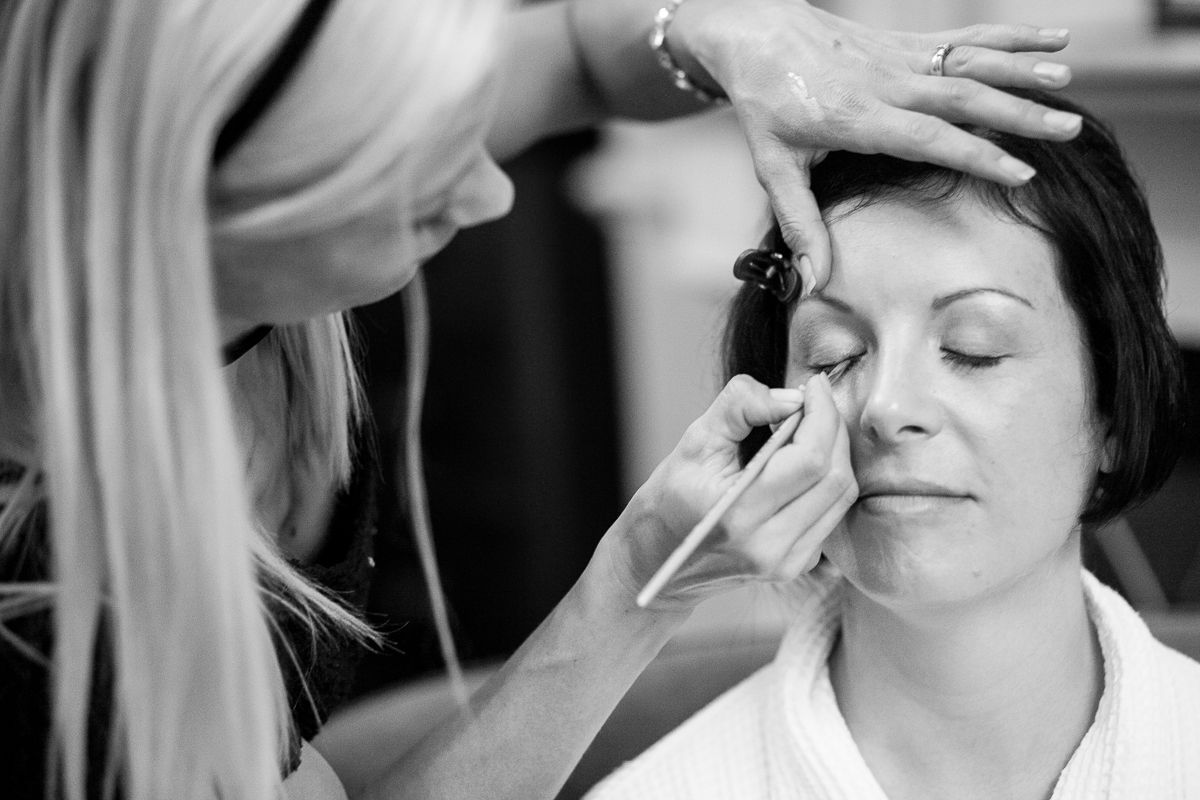 Professional makeup artist applying cosmetics during bridal preparation.
