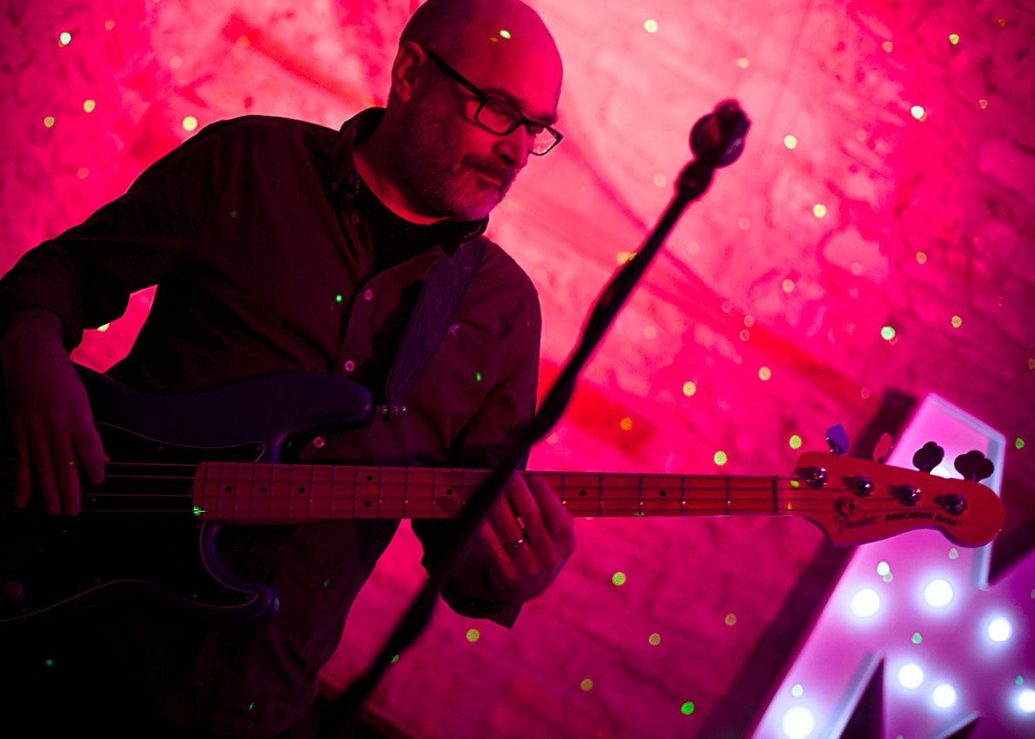 Concert wedding reception performers of Freeze at Folly Farm Somerset illuminated by dramatic red stage lighting and spotlights.