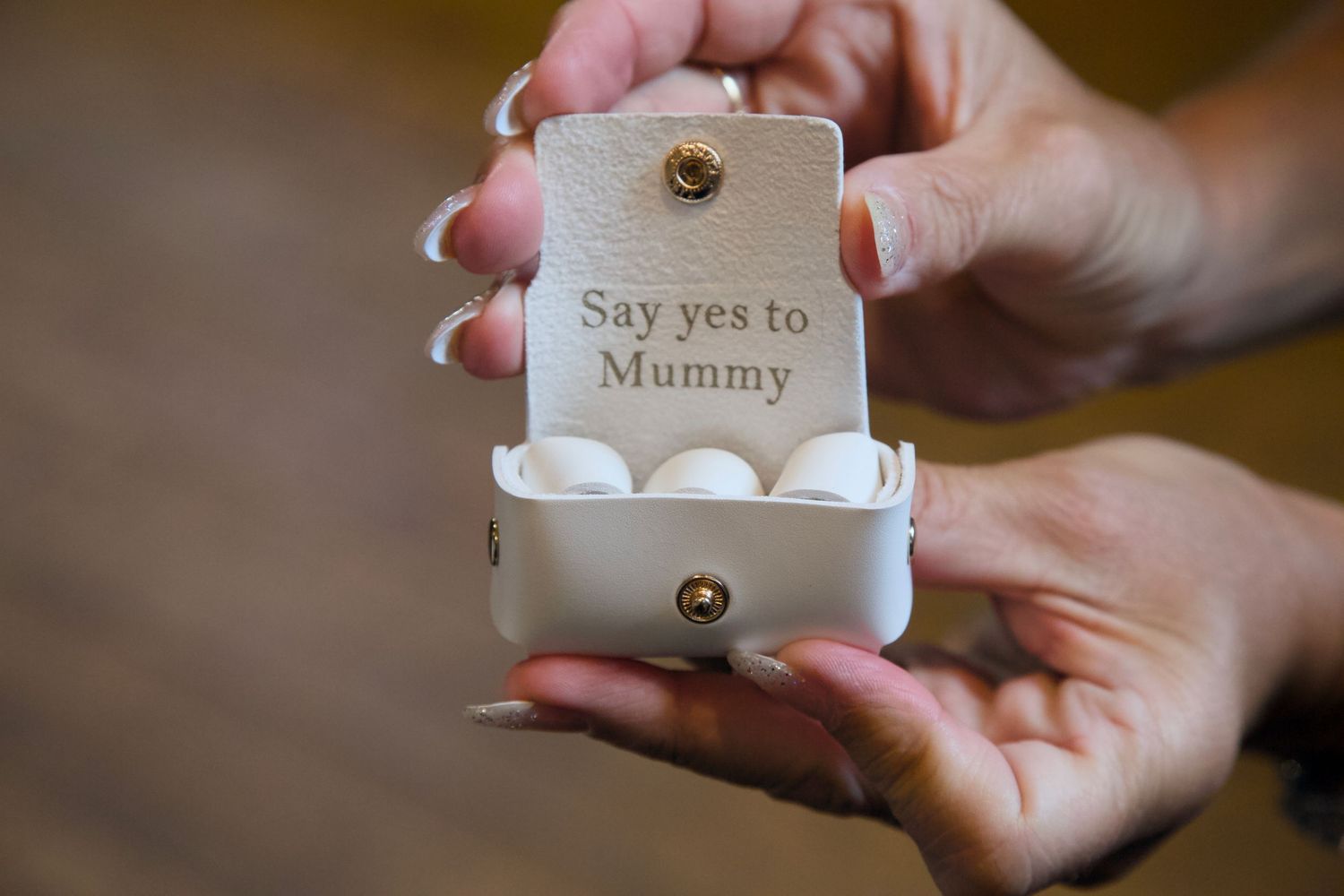 Close-up of hands holding a small wedding favor or gift box.