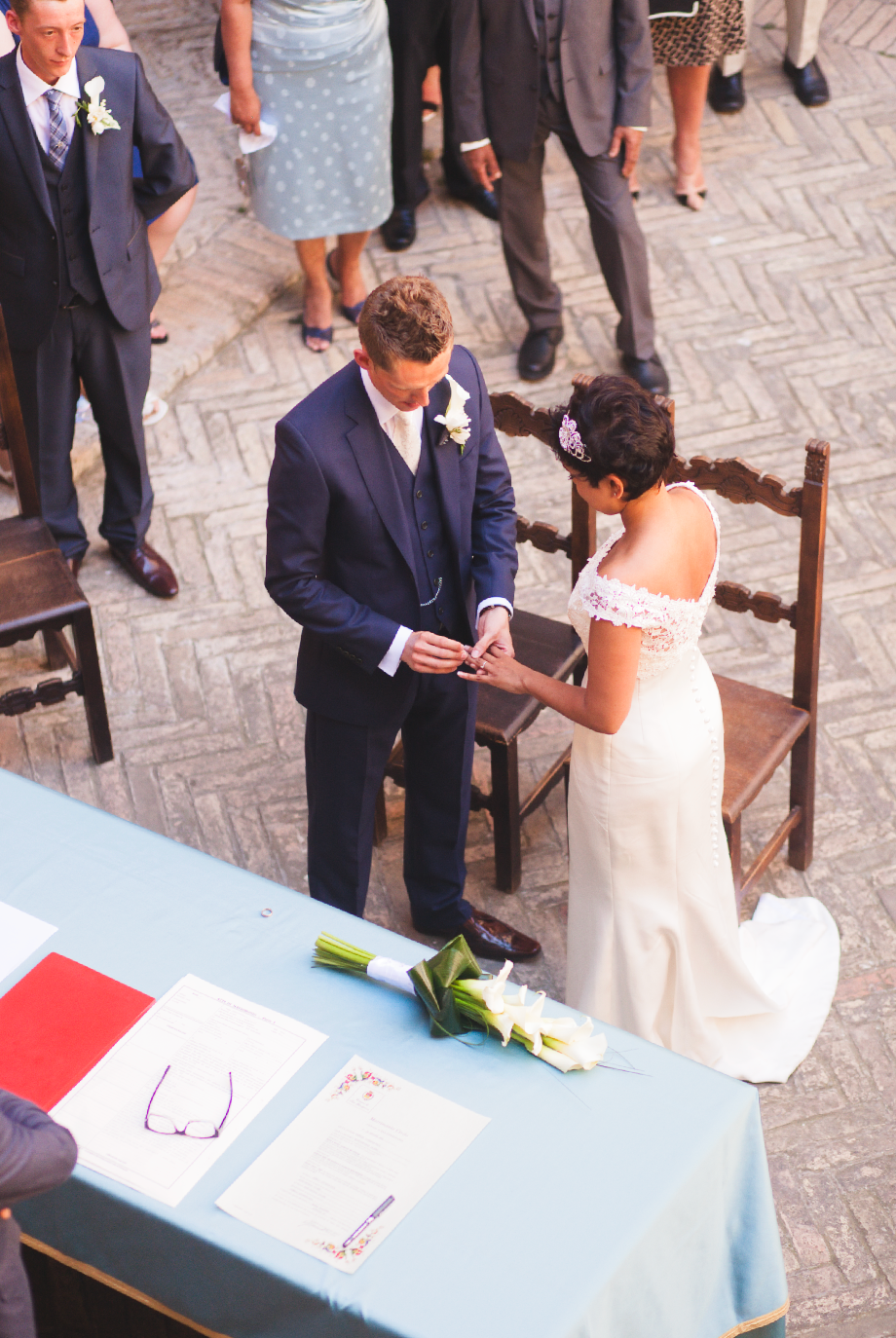 A couple exchanges rings during their wedding ceremony at a historic venue.
