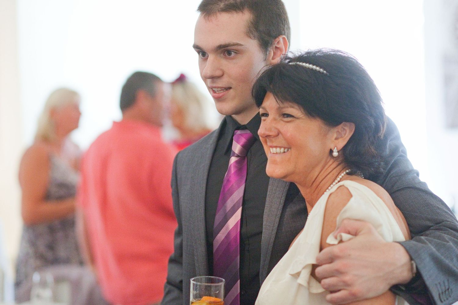 Guests laughing and socializing at an elegant indoor celebration.