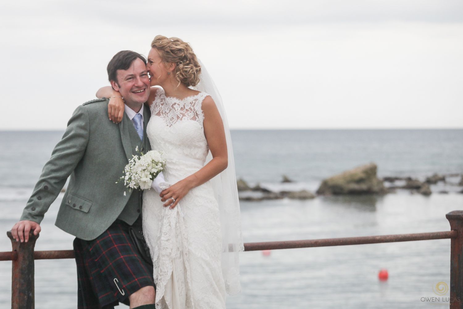 A couple shares an intimate moment during their coastal wedding photoshoot.