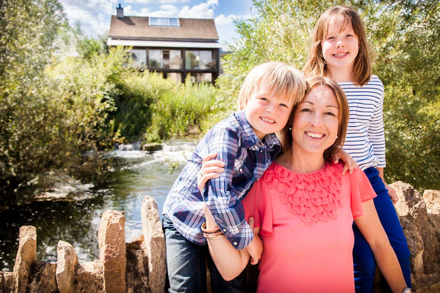 Outdoor family photo session in sunny park setting with natural expressions.
