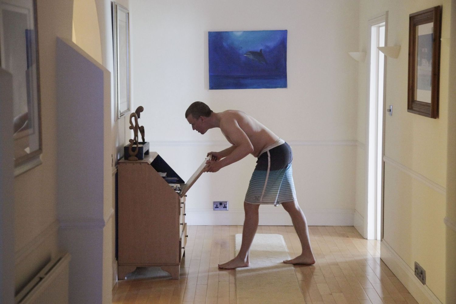Sequence of playful indoor photos showing someone jumping and dancing in a bright hallway.