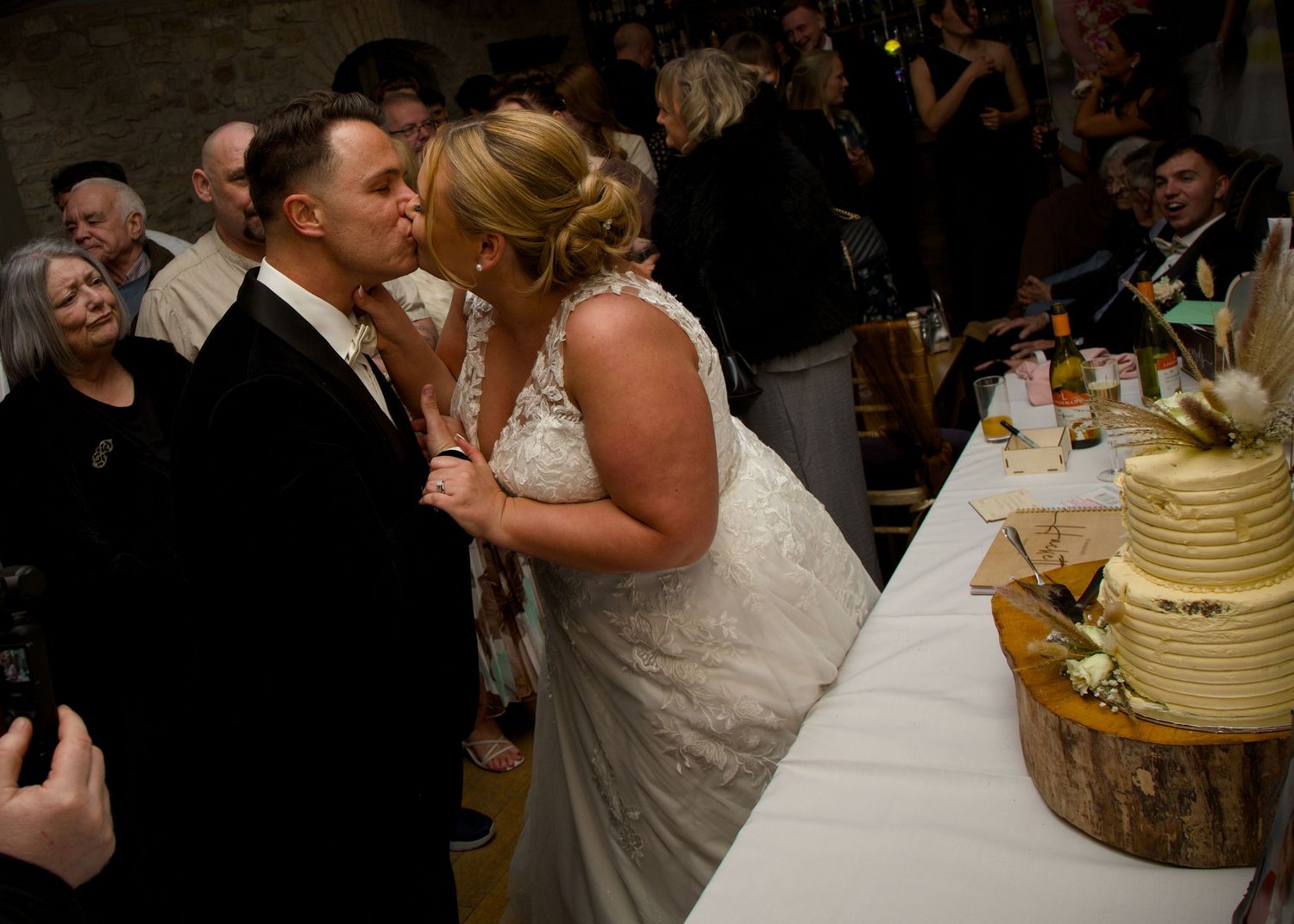Newlyweds share an intimate moment beside their wedding cake during the reception.