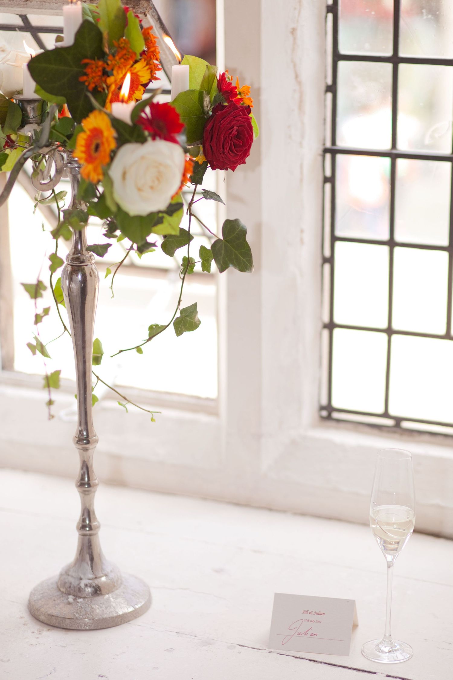 Beautiful table settings with colorful floral arrangements and elegant place cards in a bright white venue.