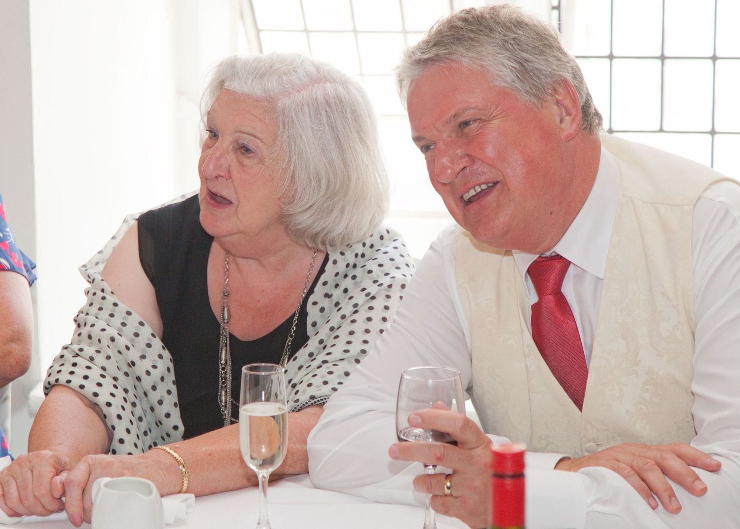 Guests enjoying conversation at a formal event with white tablecloths.
