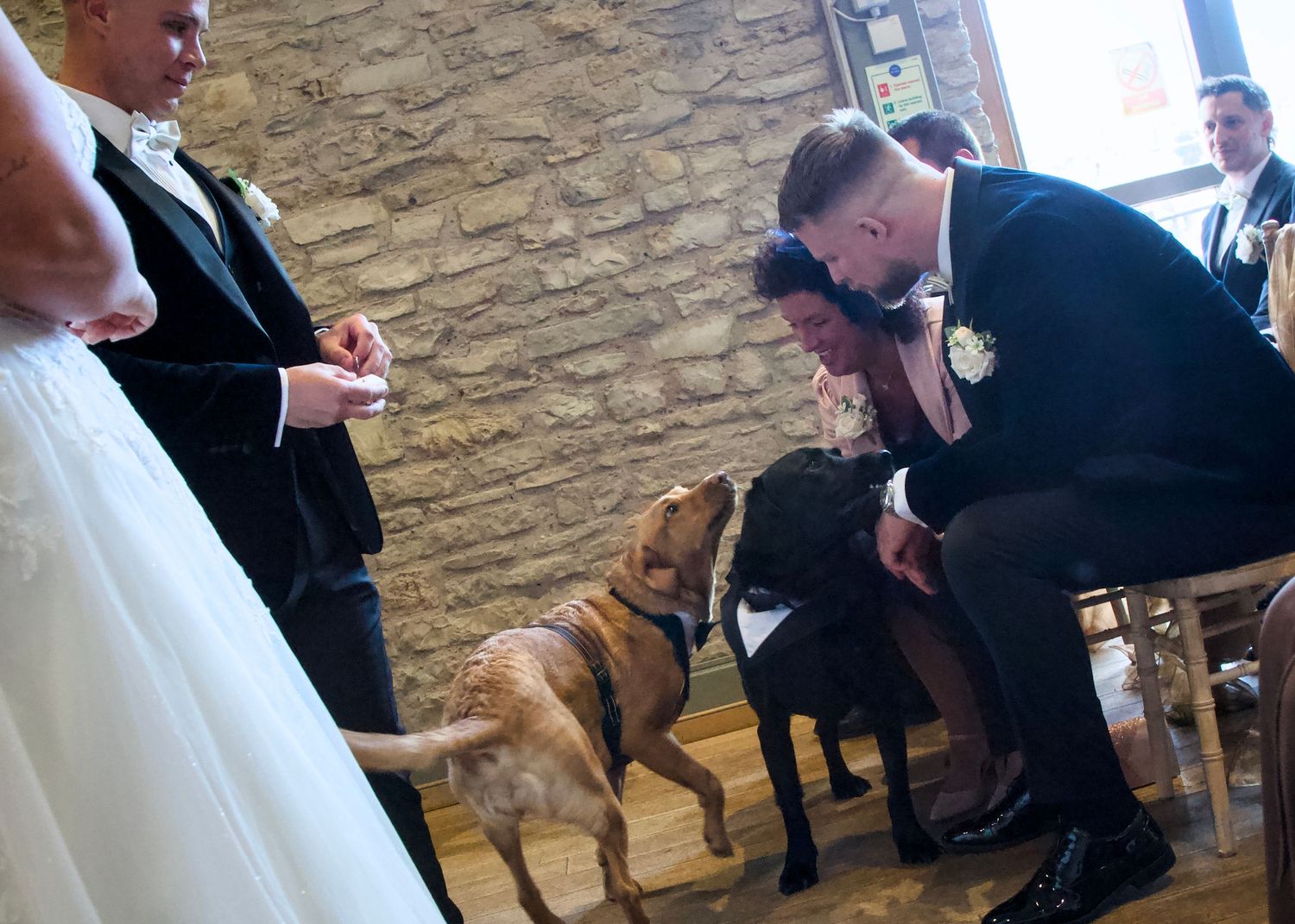 Wedding celebration in a rustic venue with stone walls and wooden floors.