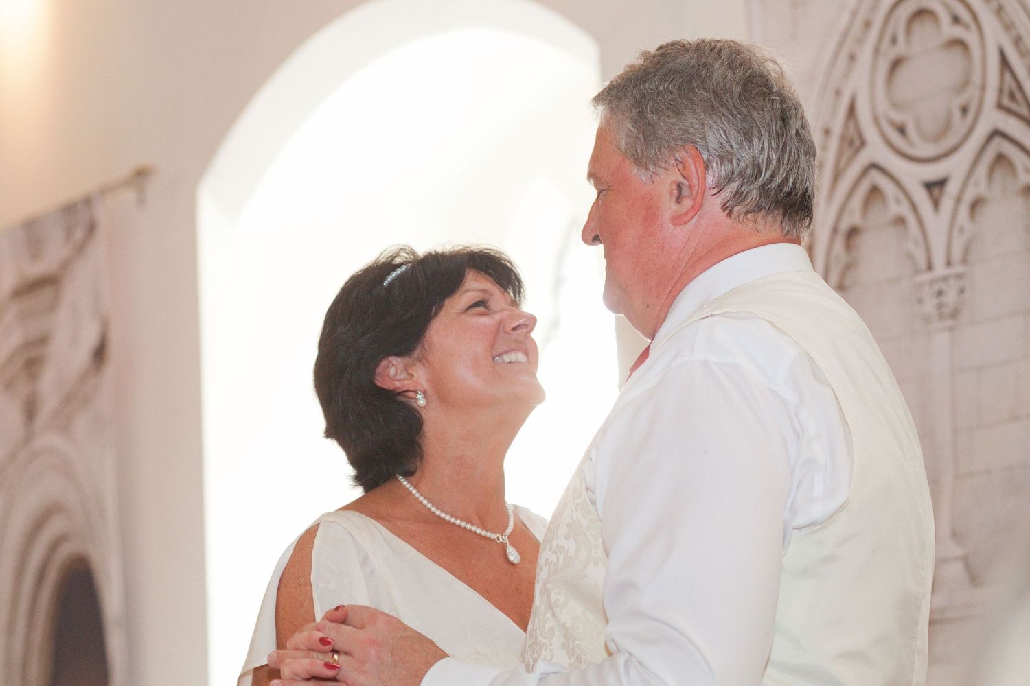 Couples dancing together at an elegant event in white formal attire.