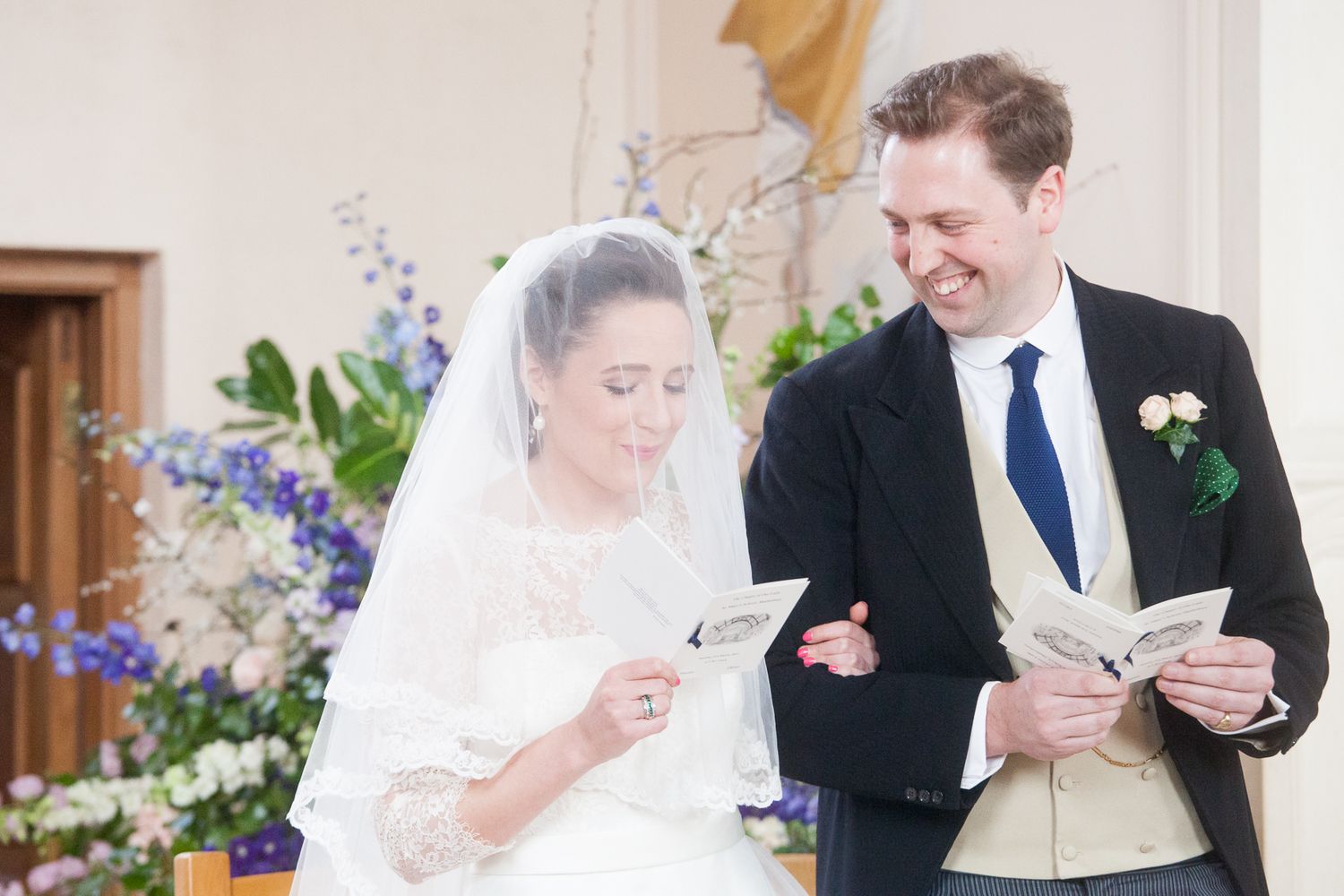 Wedding couple shares candid moment while reading during ceremony.