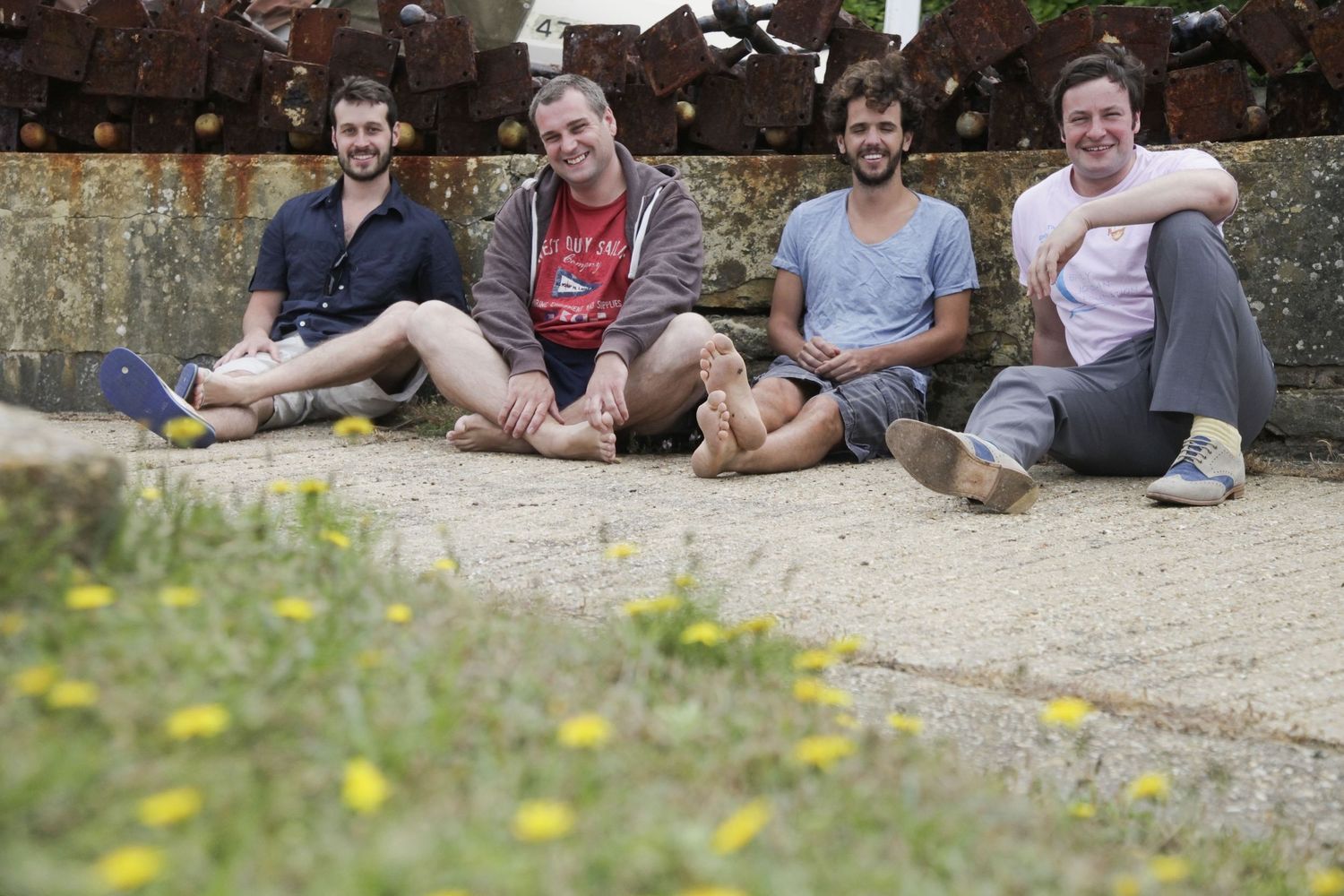 Friends relaxing together on stone steps outdoors on a sunny day.