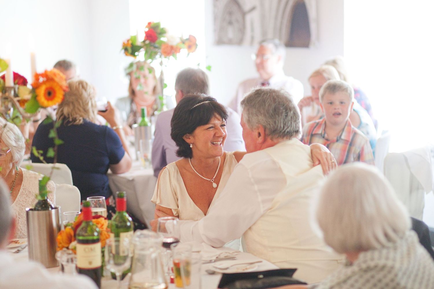 Wedding guests mingling at tables during an elegant indoor reception.