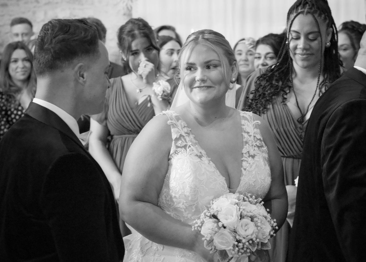 Wedding ceremony guests watching the proceedings in a traditional indoor venue setting.