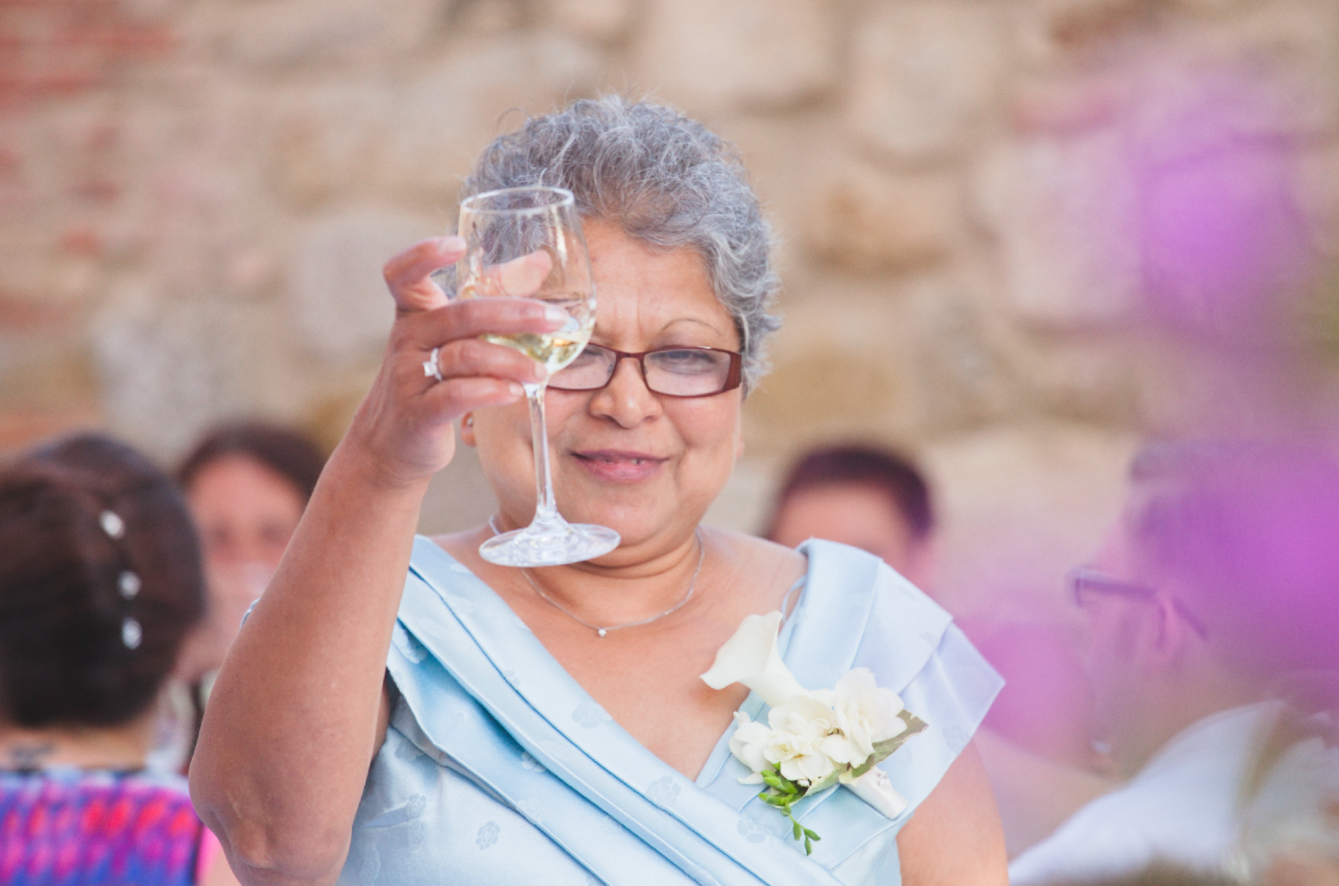 Wedding guests enjoying drinks and conversation at an outdoor reception.