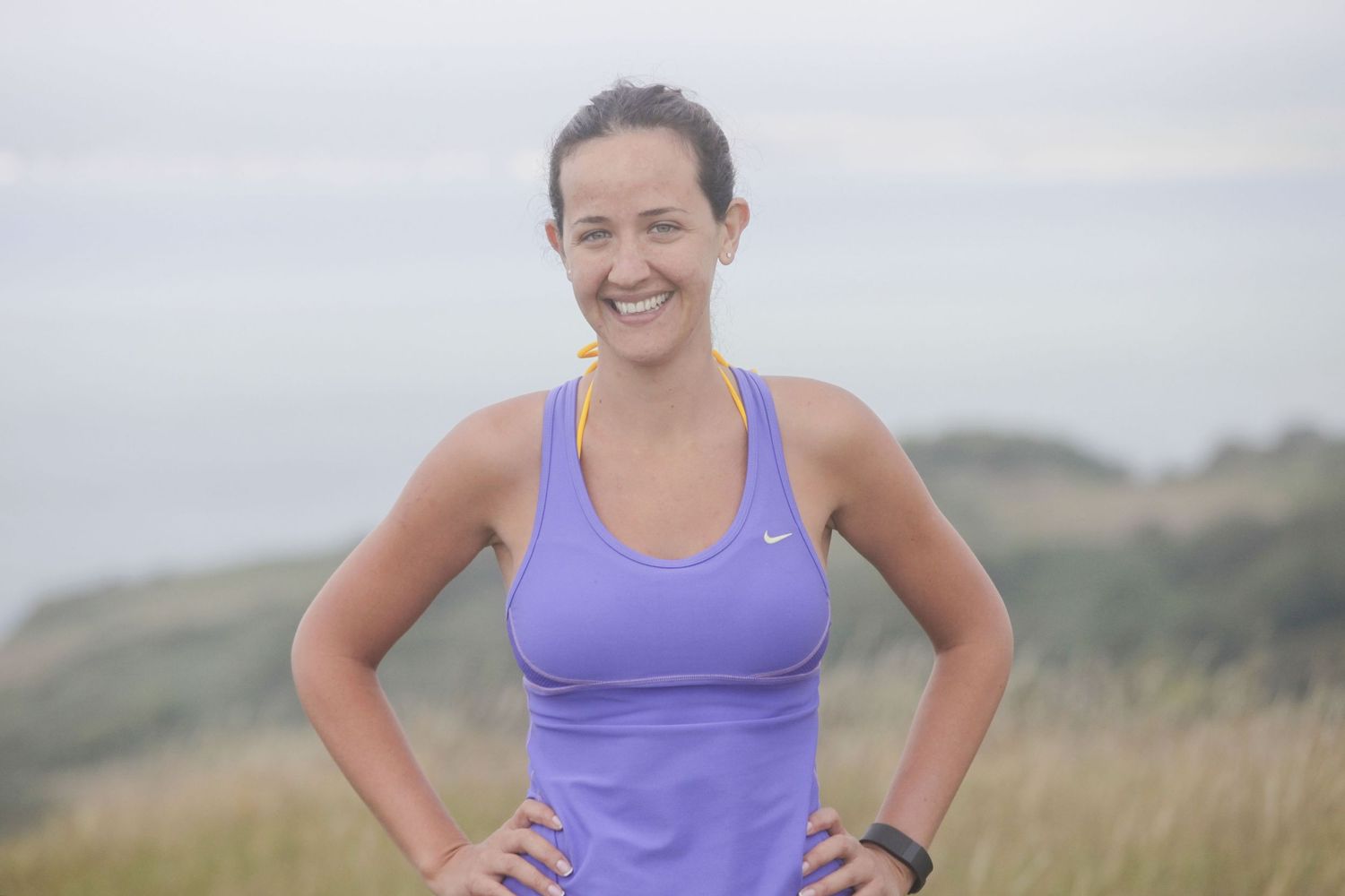 Athletic figures in colorful workout gear posing on hilltop trail.