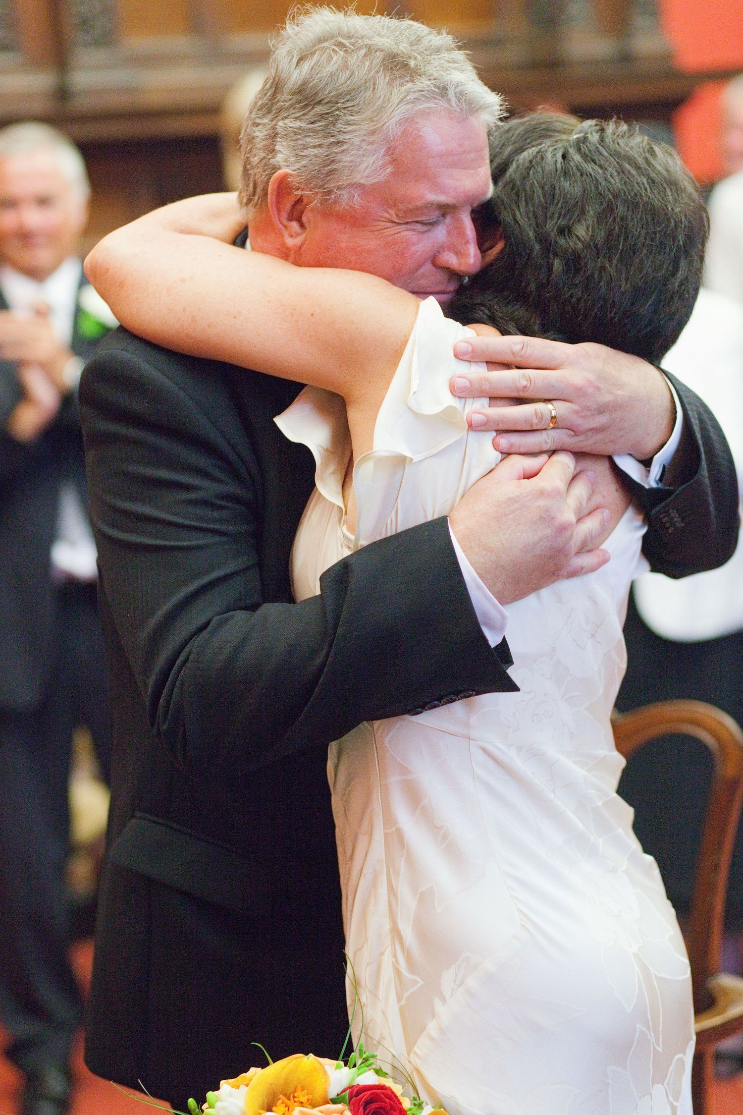 Wedding couple sharing intimate moments in a series of photos with a coral backdrop.