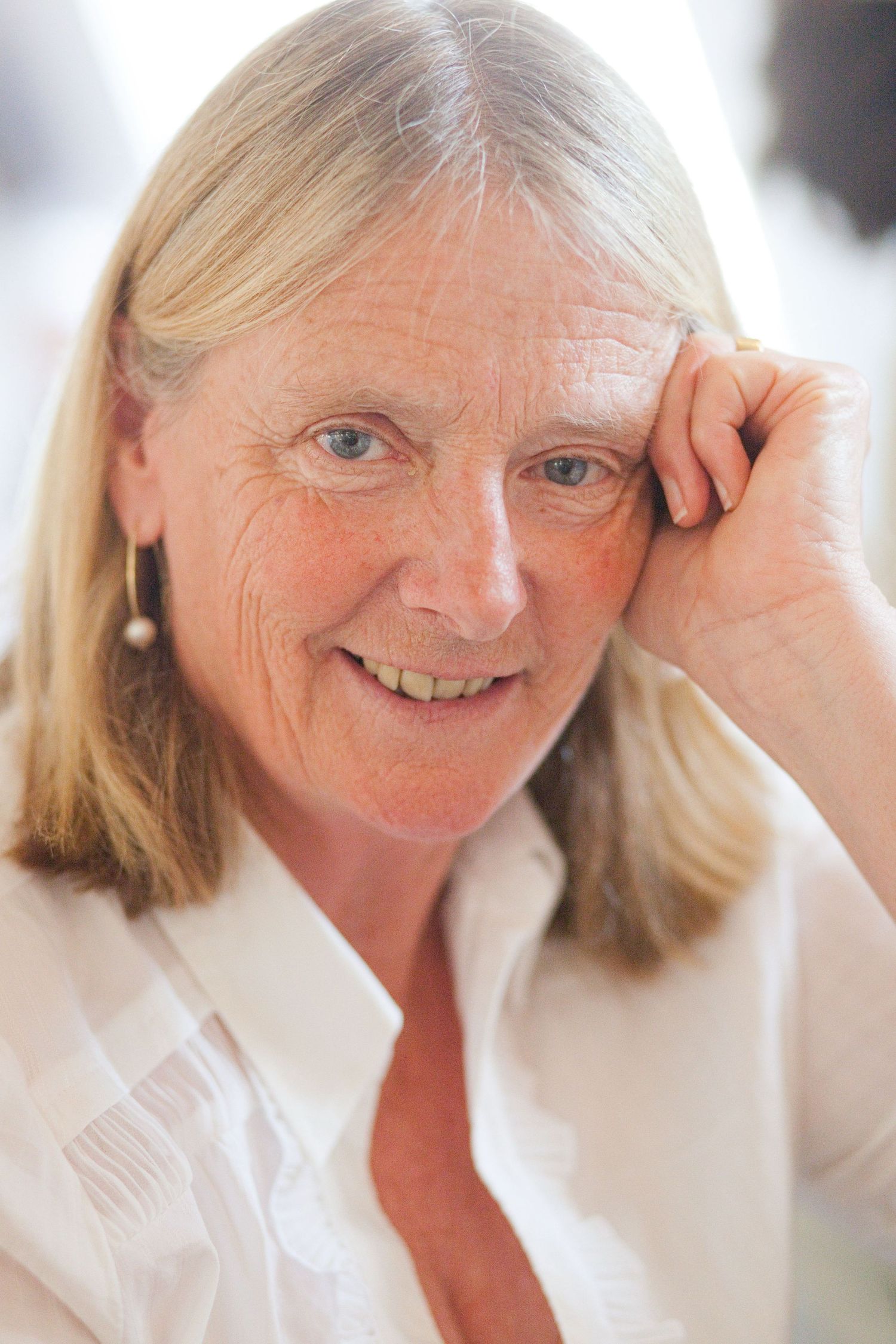 Close-up portrait of a woman in white smiling warmly.
