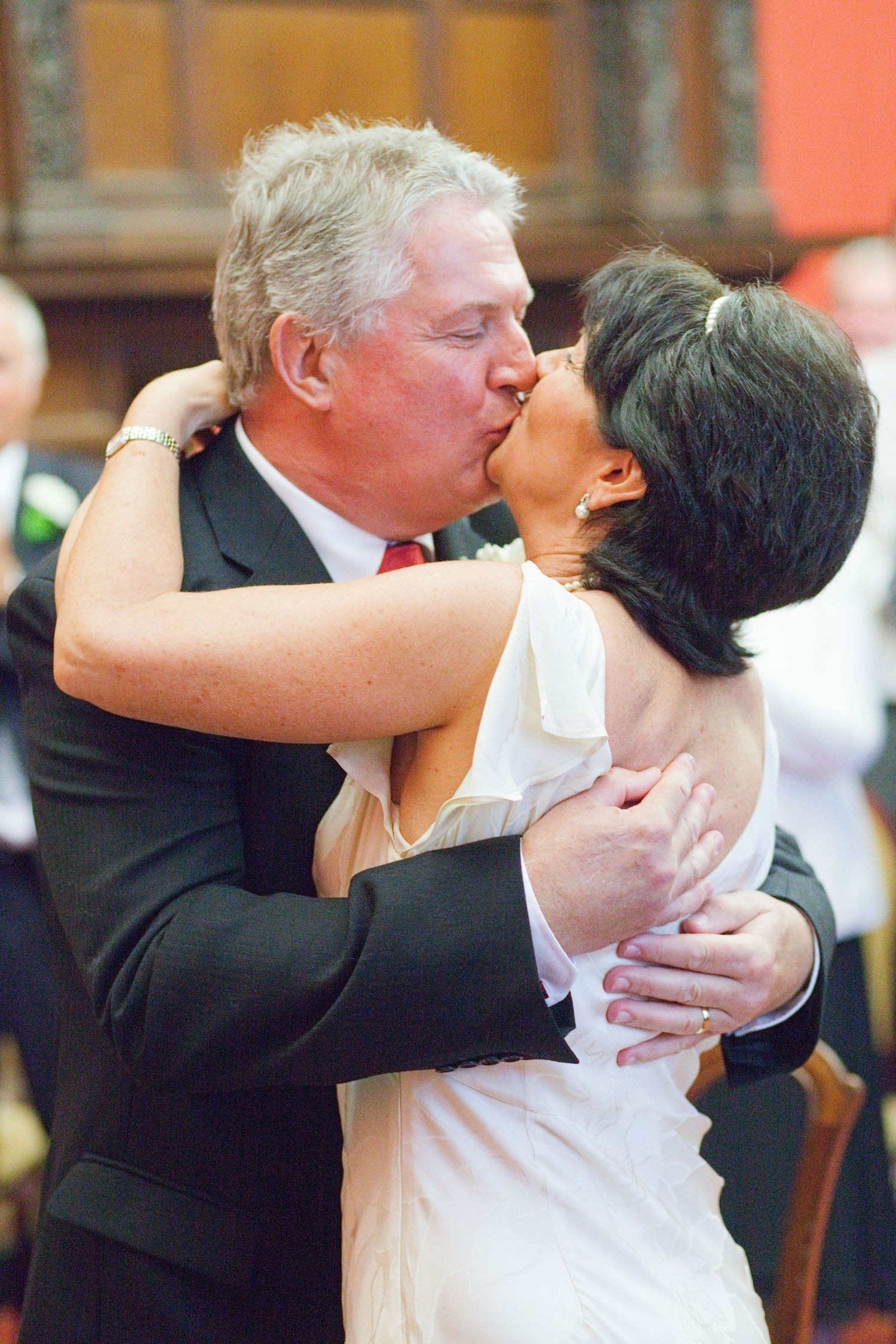 Series of wedding photos showing couple sharing affectionate moments against coral-colored wall.