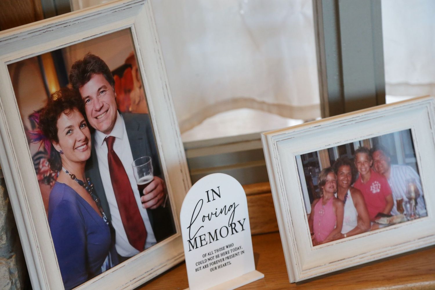 Collection of framed family photographs displayed on wooden surface.