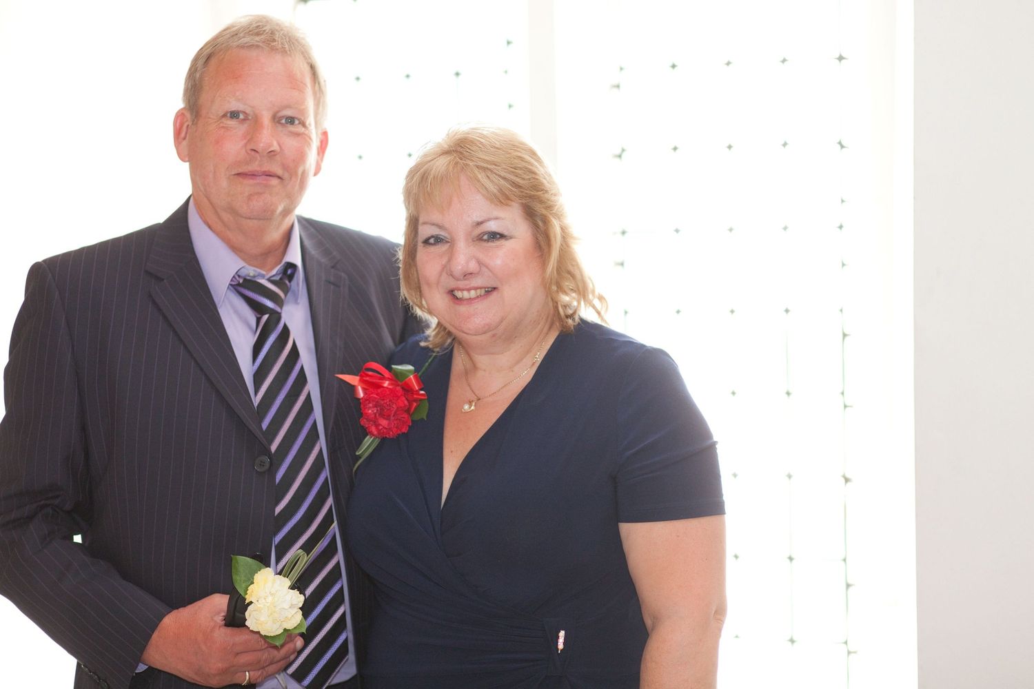 Wedding guests in formal attire gather for photos at an elegant indoor reception.