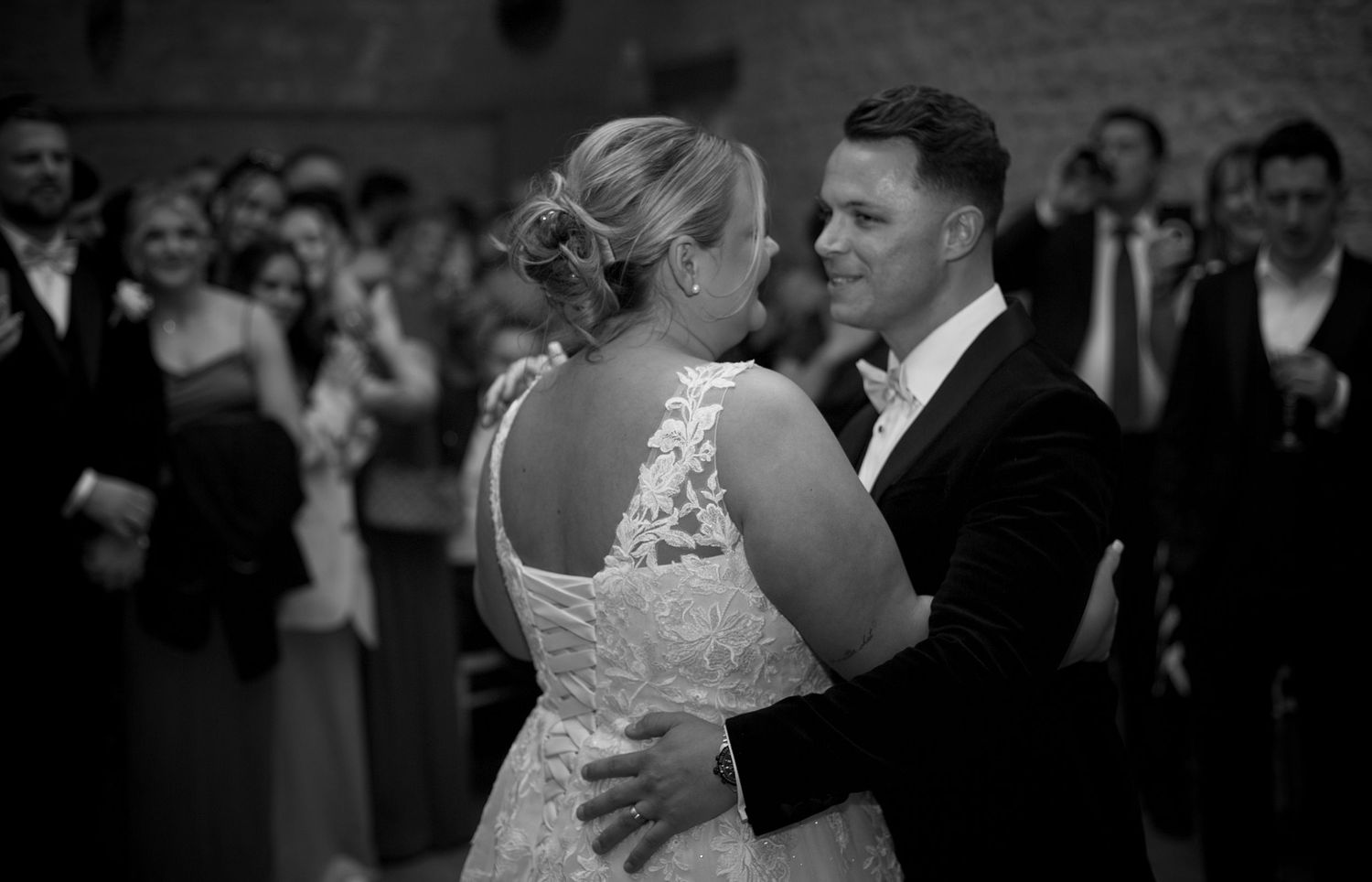 Black and white photo of a couple dancing closely at their wedding celebration.