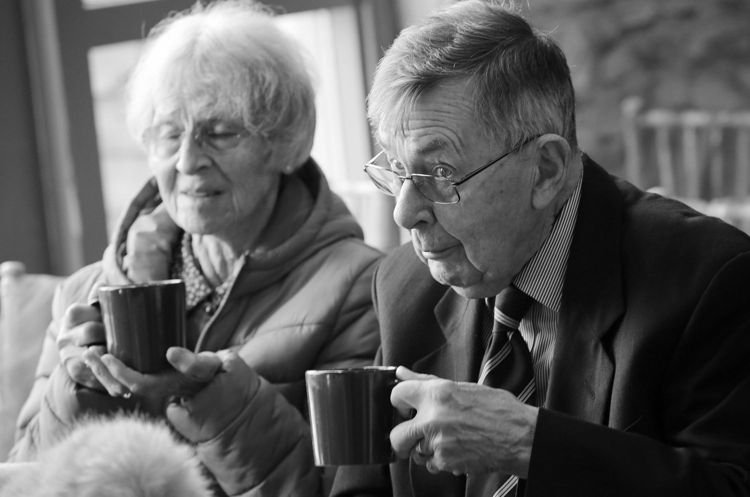Elderly guests enjoy drinks and conversation at a formal event.