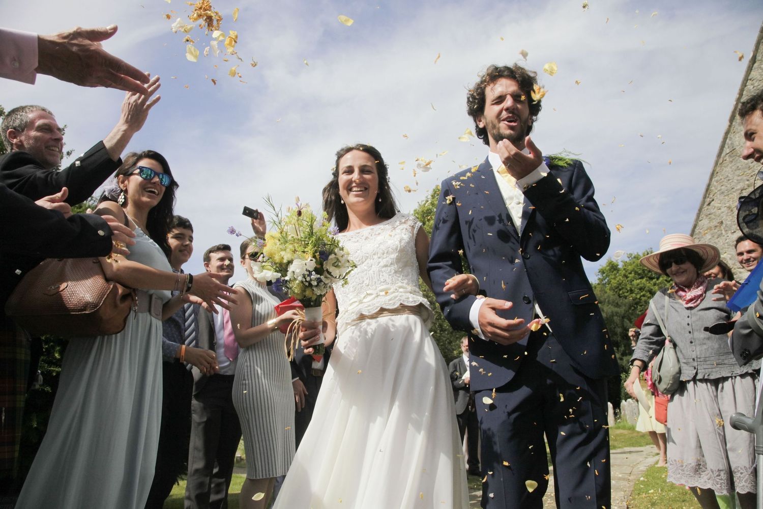 Joyful confetti toss moment captured during outdoor wedding celebration.