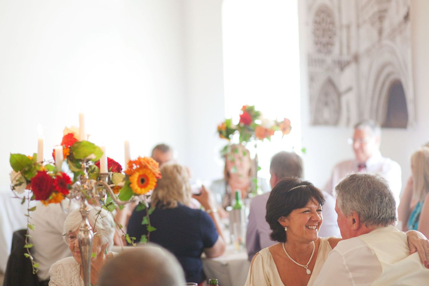 Elegant wedding reception hall with gothic architecture and floral decorations.