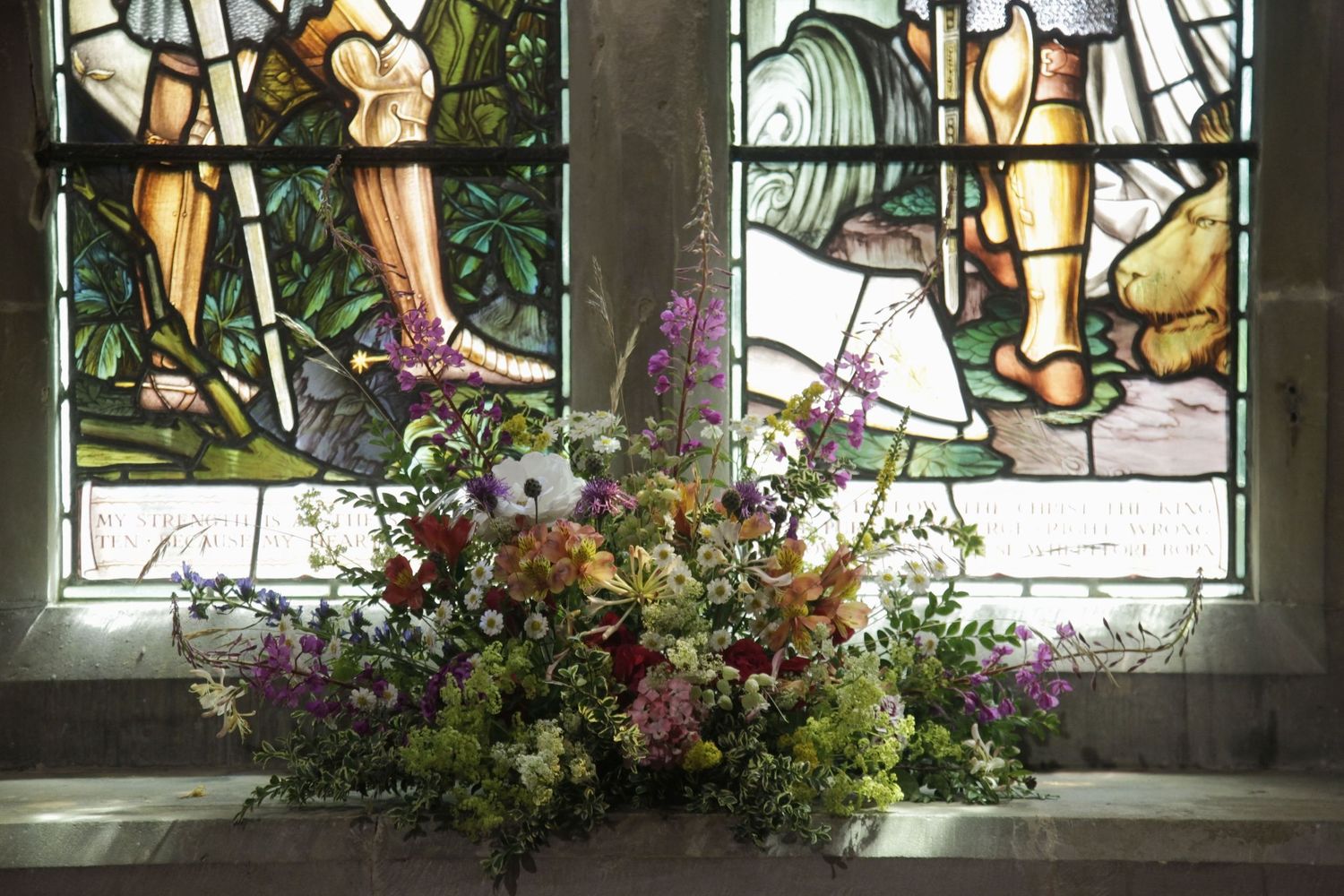 Stained glass windows with floral decorations along the church windowsill.