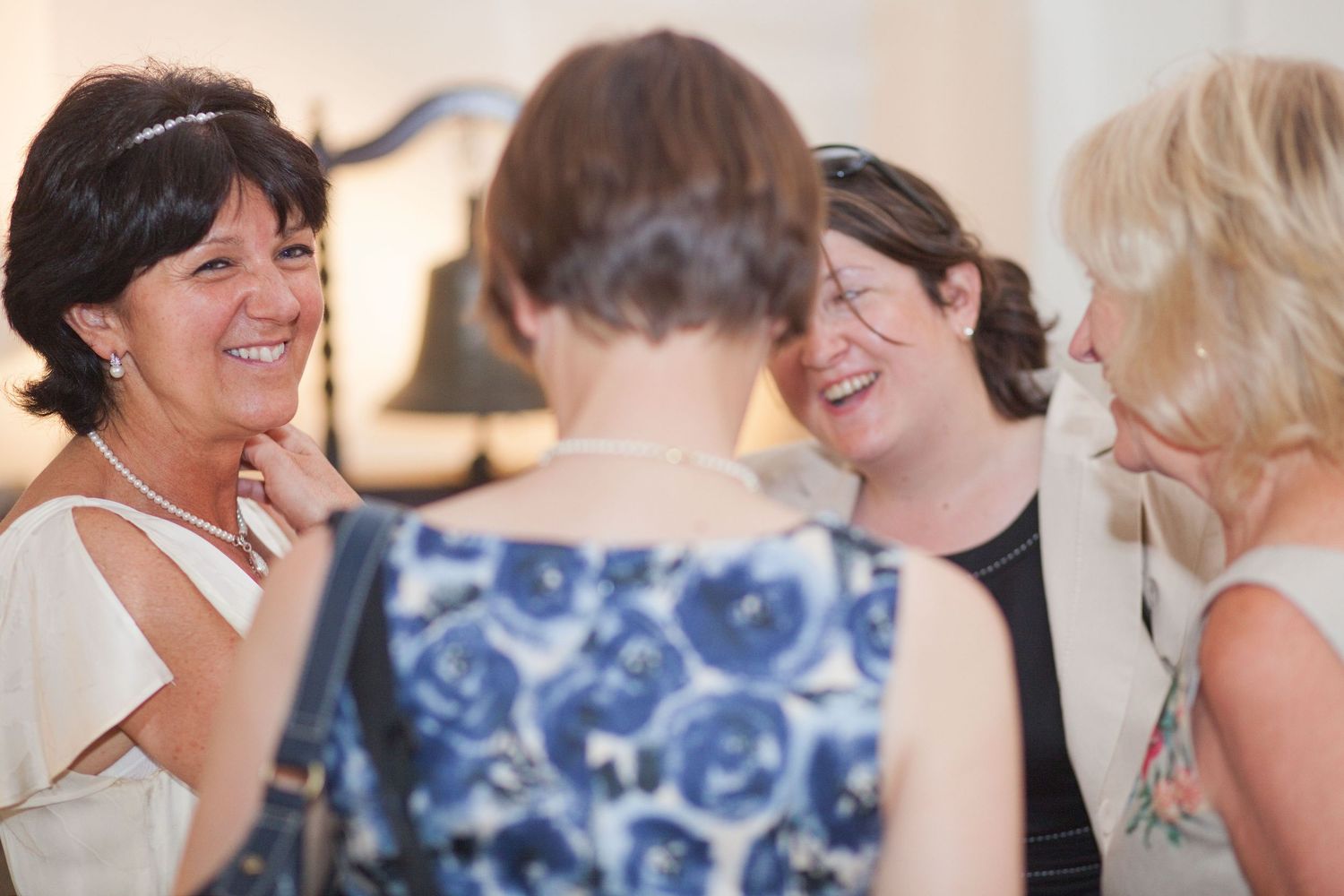 Guests in blue and white attire share laughs during a formal celebration.