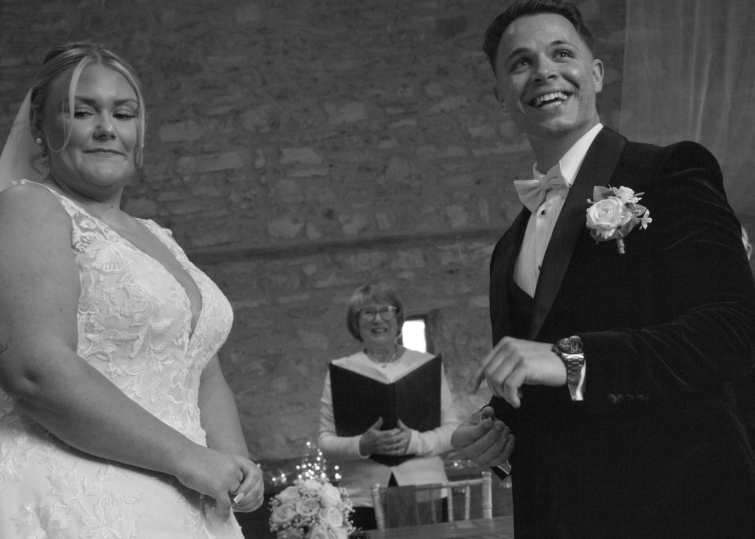Candid wedding moments captured against a textured stone wall backdrop.