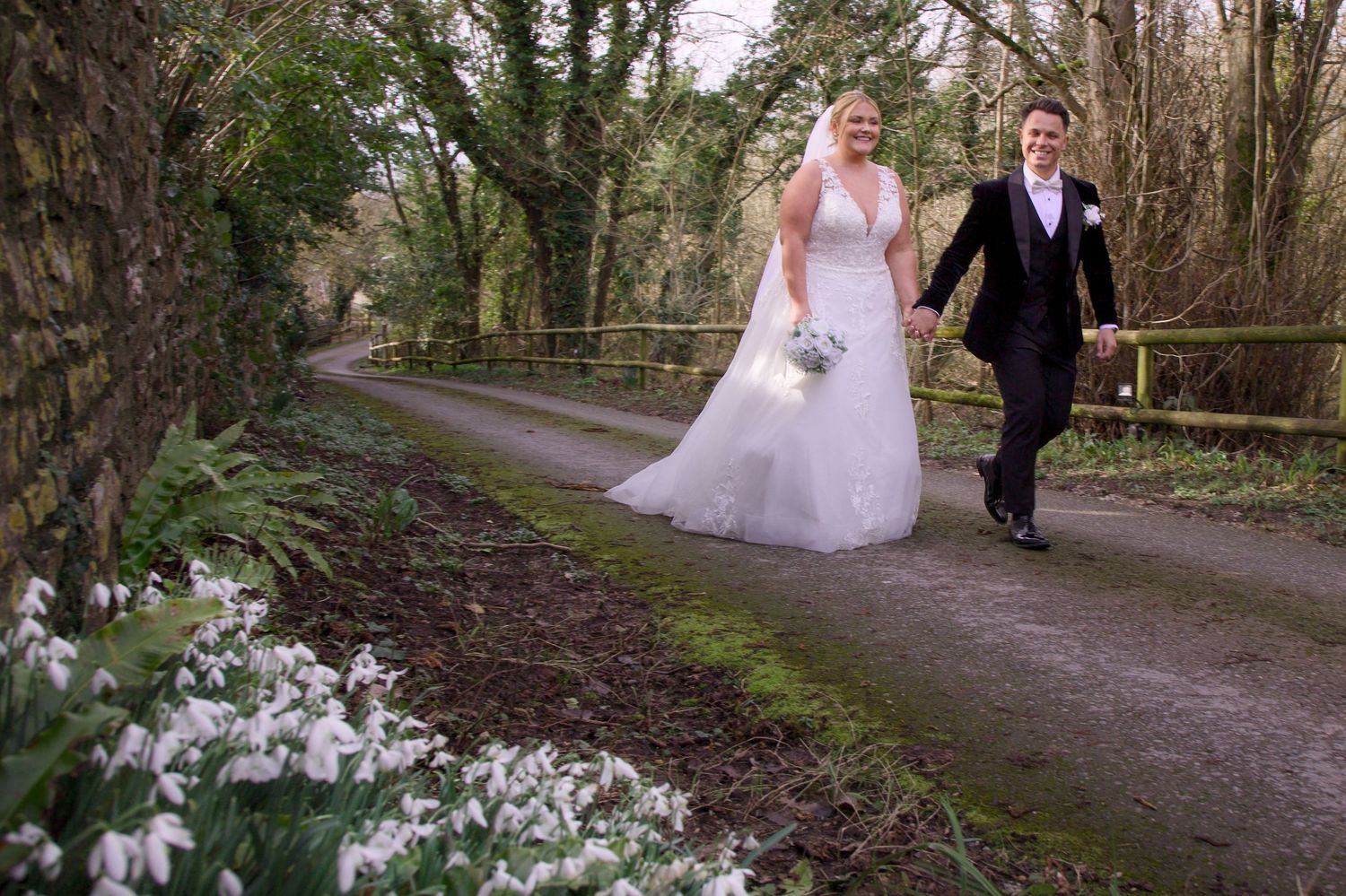 Romantic wedding photos taken along tree-lined woodland path at Folly Farm Somerset wedding