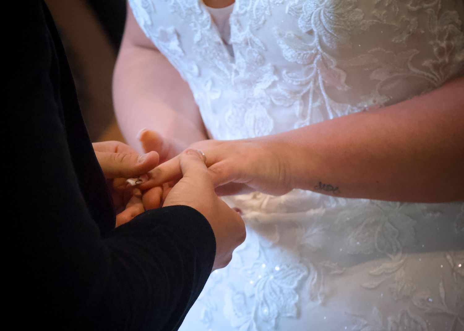 Detail shot of a bride's lace wedding dress during the celebration.
