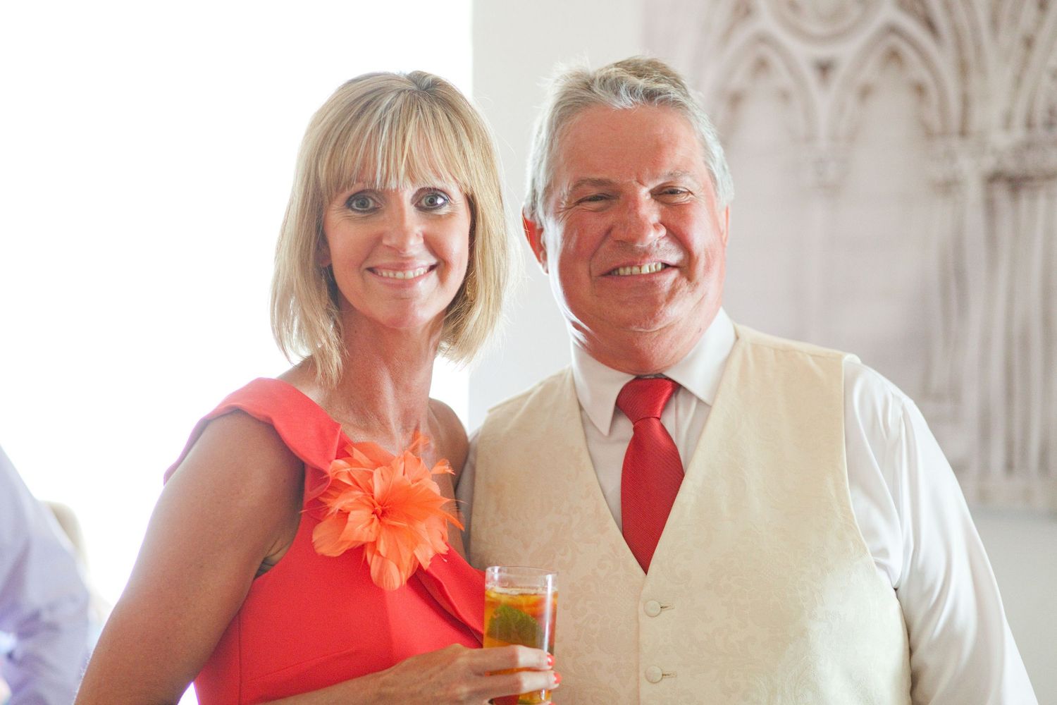 People in coral and white attire posing at a formal celebration.