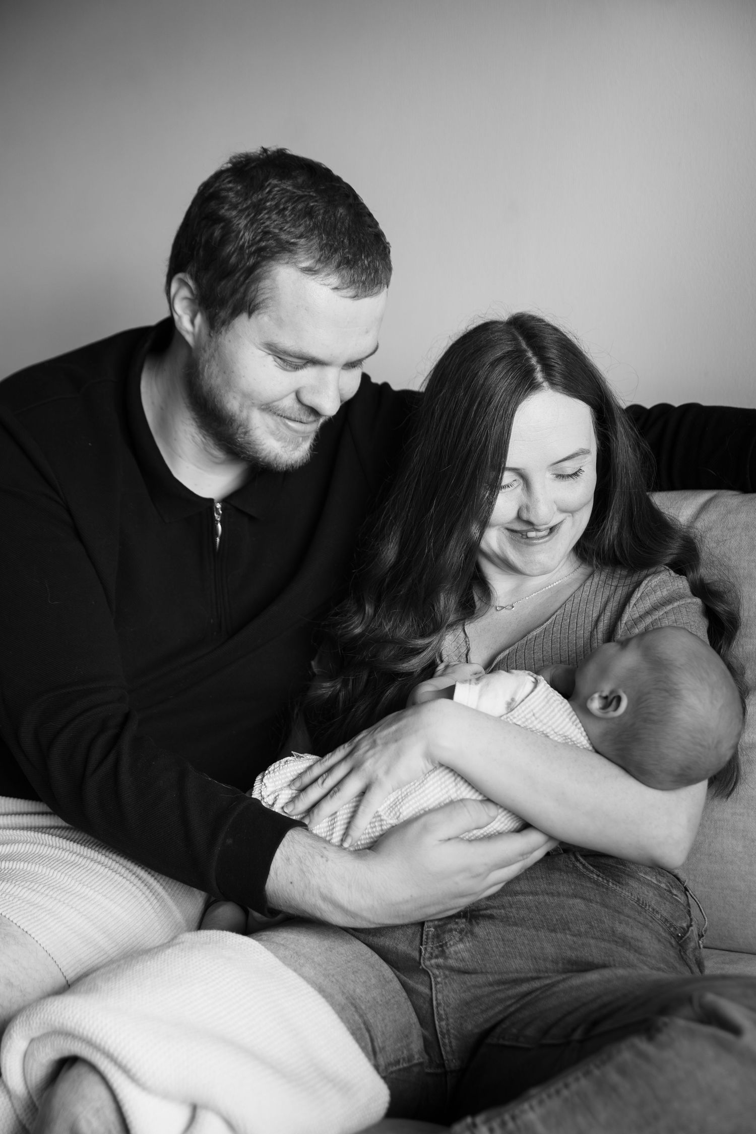 Black and white series showing tender moments between a couple relaxing on a couch.