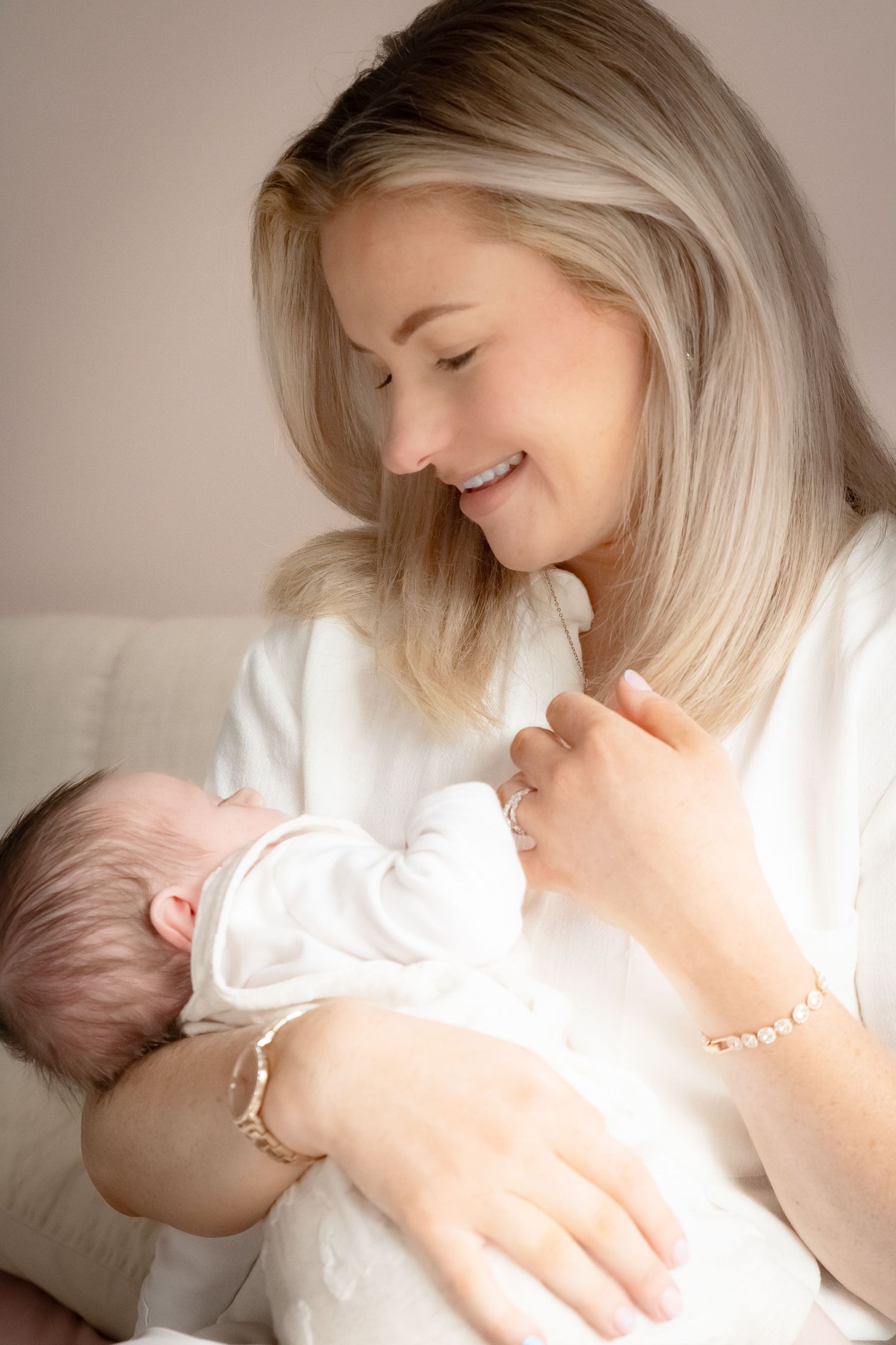Gentle nurturing moments with a newborn baby in soft white tones and natural lighting.