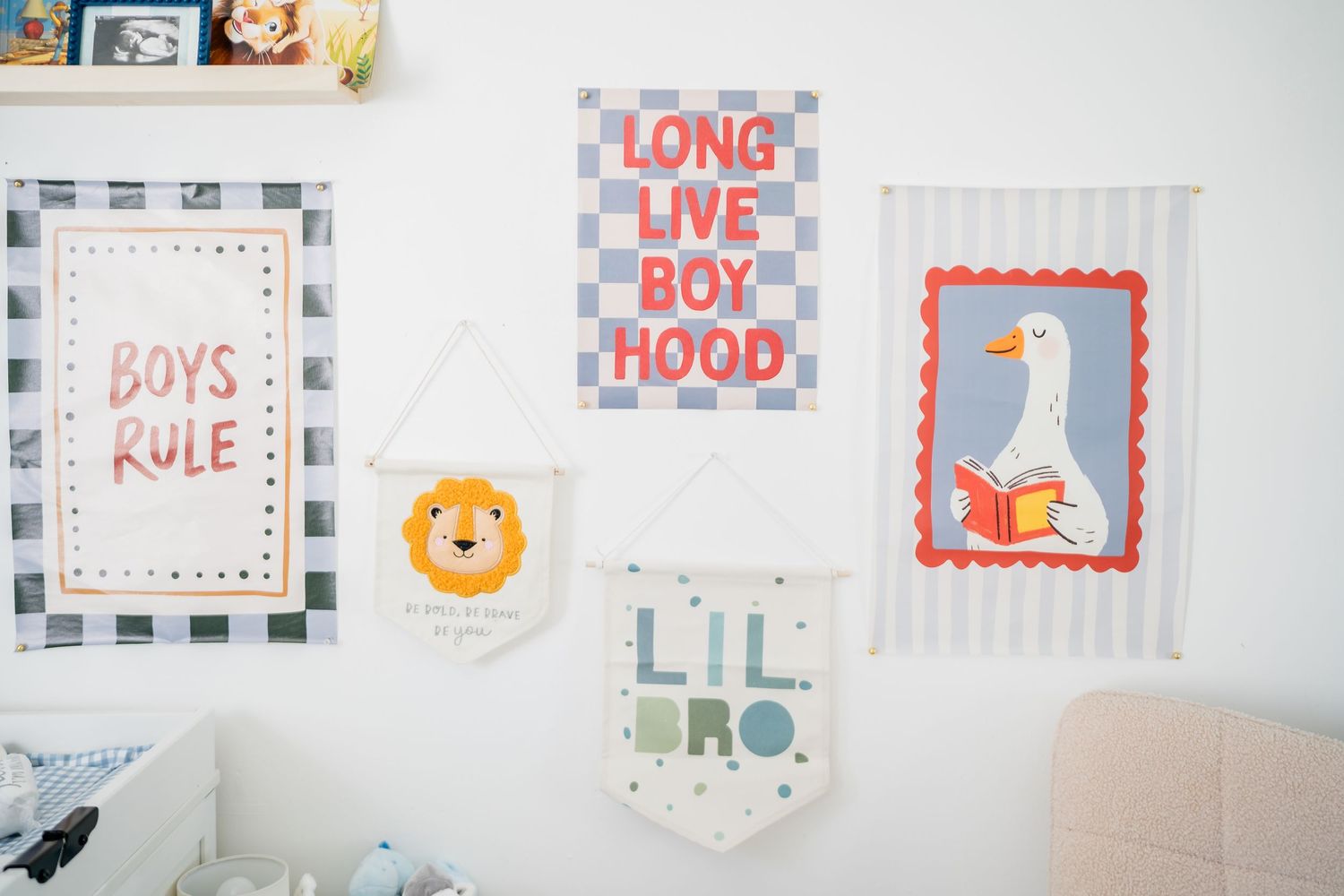 Boys nursery wall decor featuring colorful banners with phrases Boys Rule, Long Live Boyhood, Lil Bro, and a cute goose illustration.