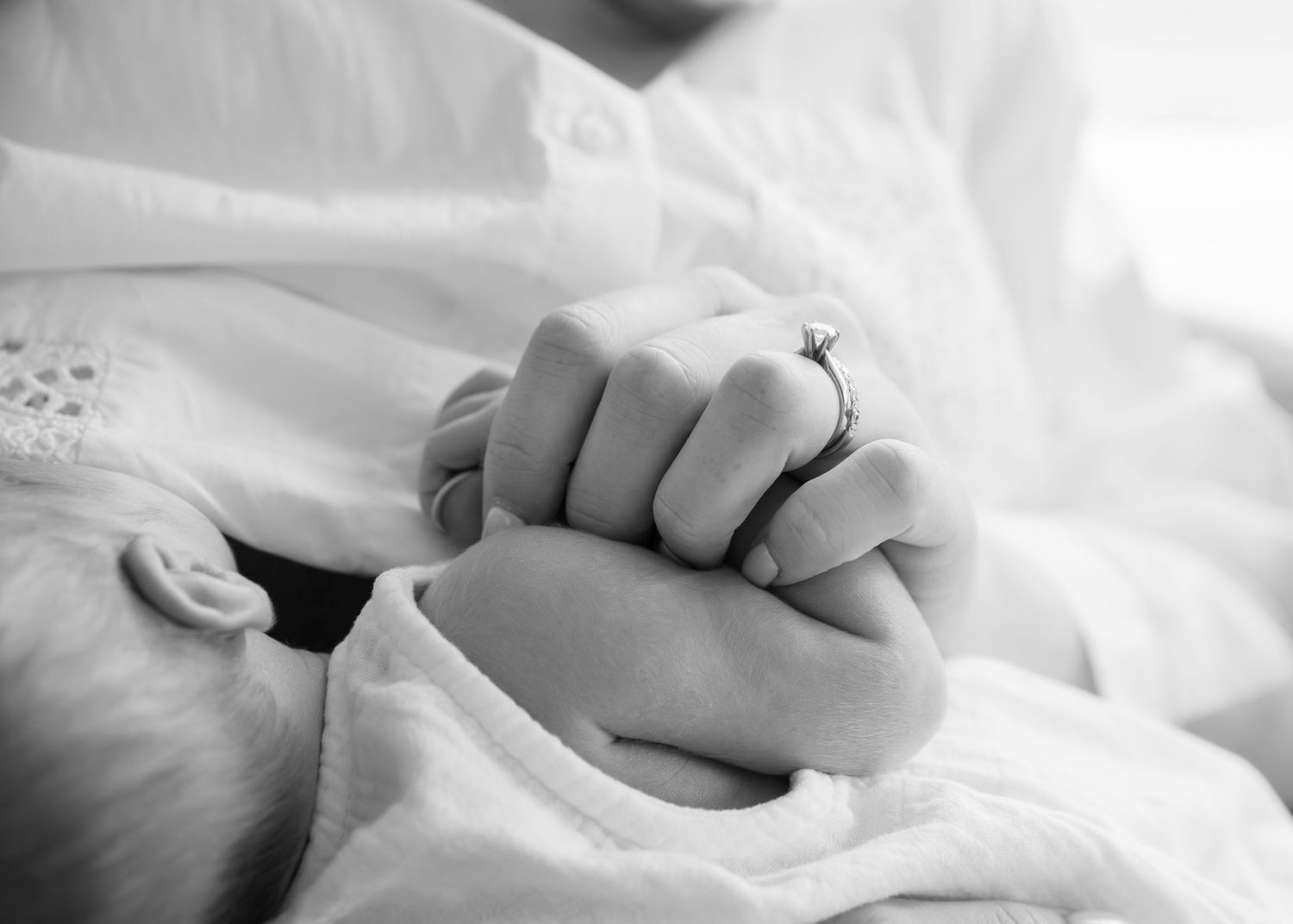 Close-up detail shots of gentle hands and tender moments in white bedding.