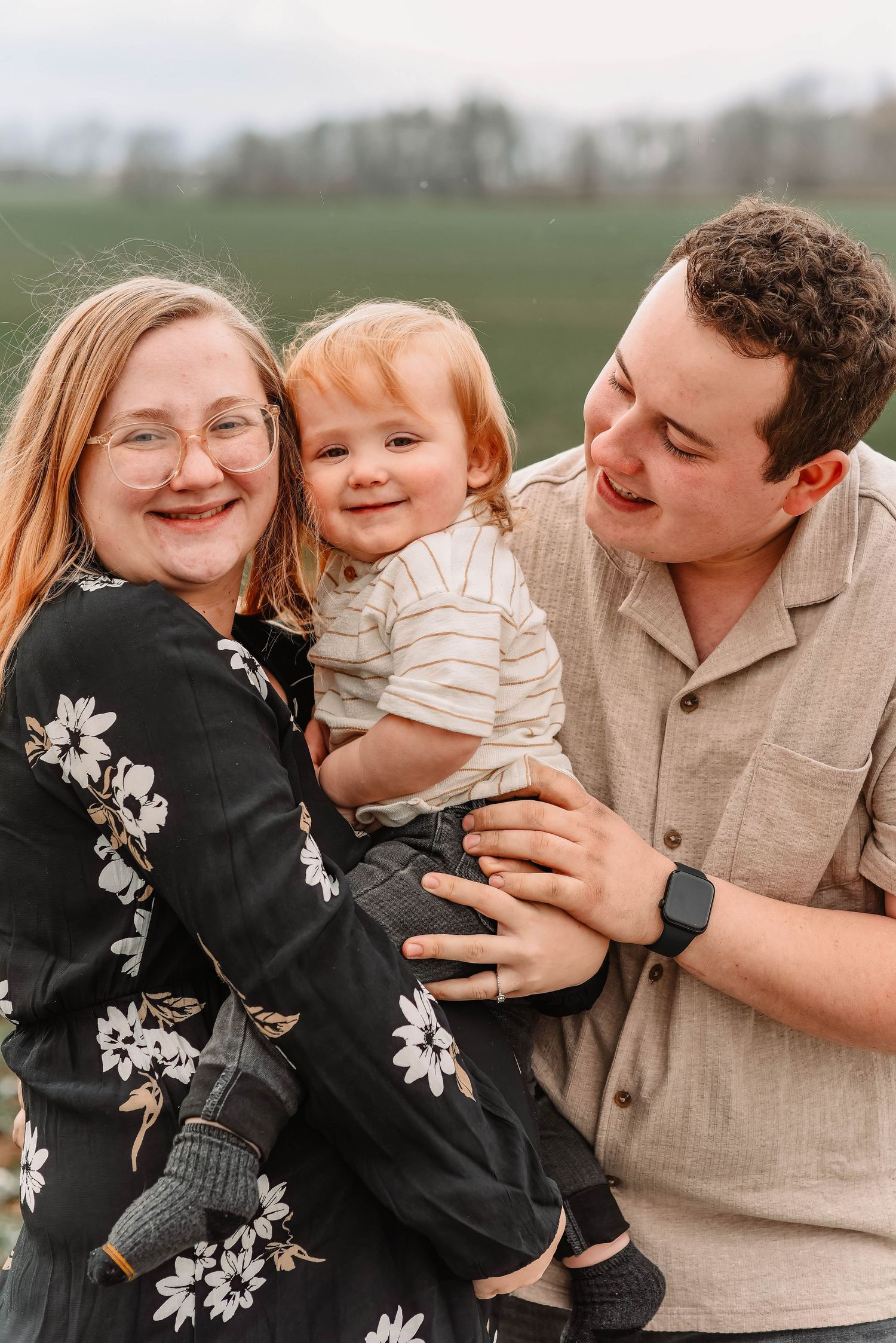 Family shares joyful moments together outdoors in coordinated neutral outfits.
