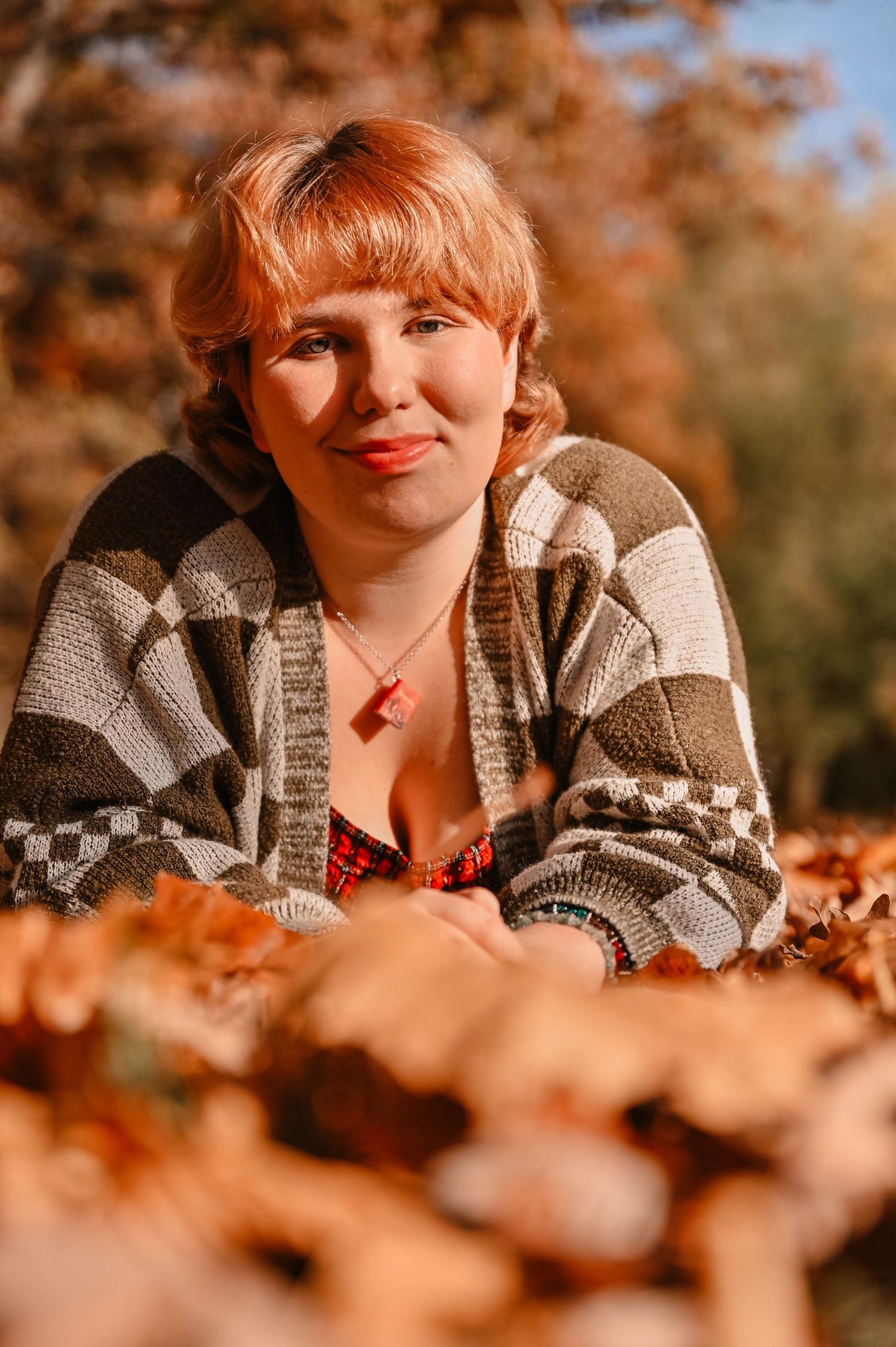 A cozy autumn portrait featuring a knit sweater among fallen orange leaves.